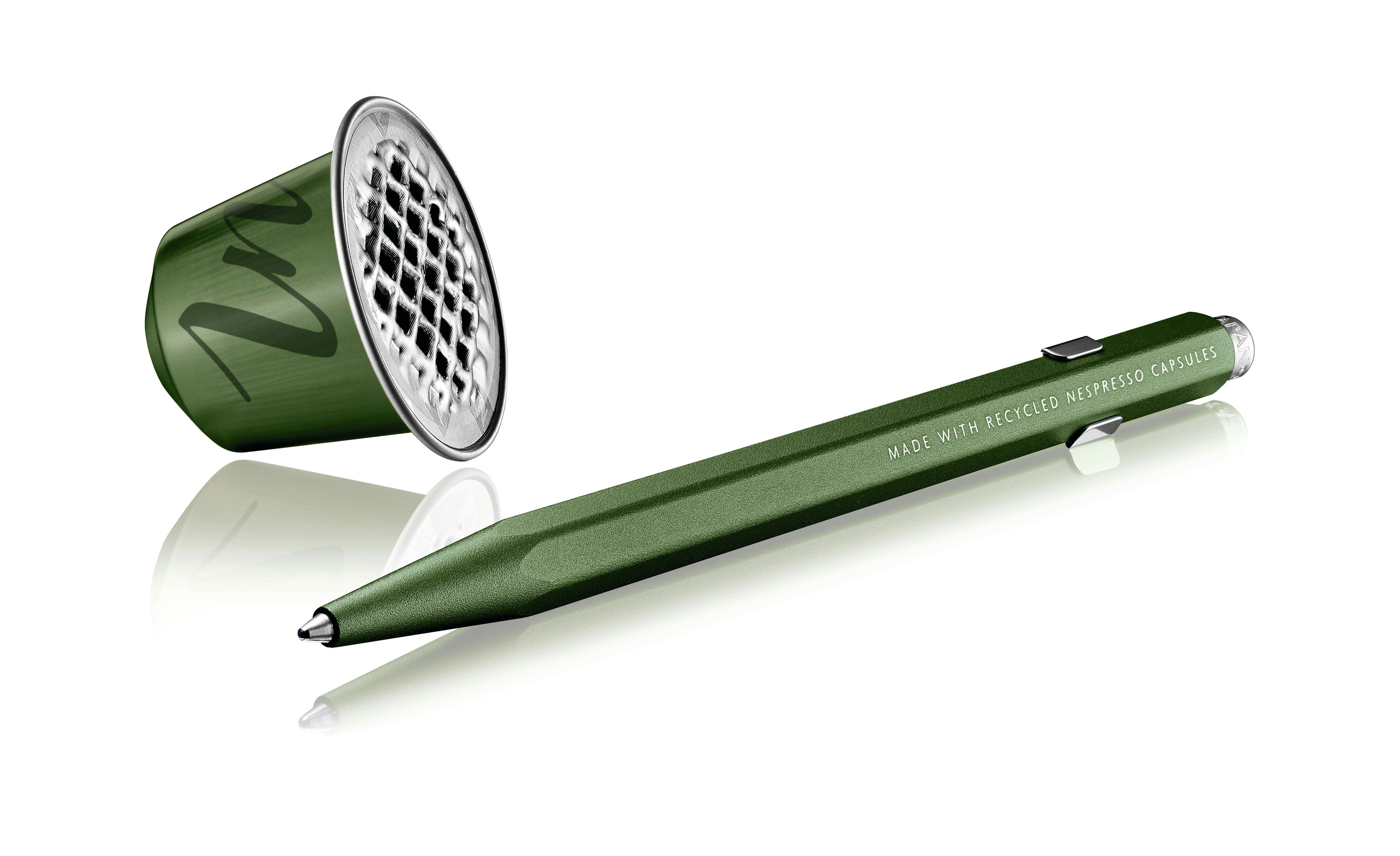 Caran d'Ache x Nespresso 849 Pen next to a green aluminum coffee pod