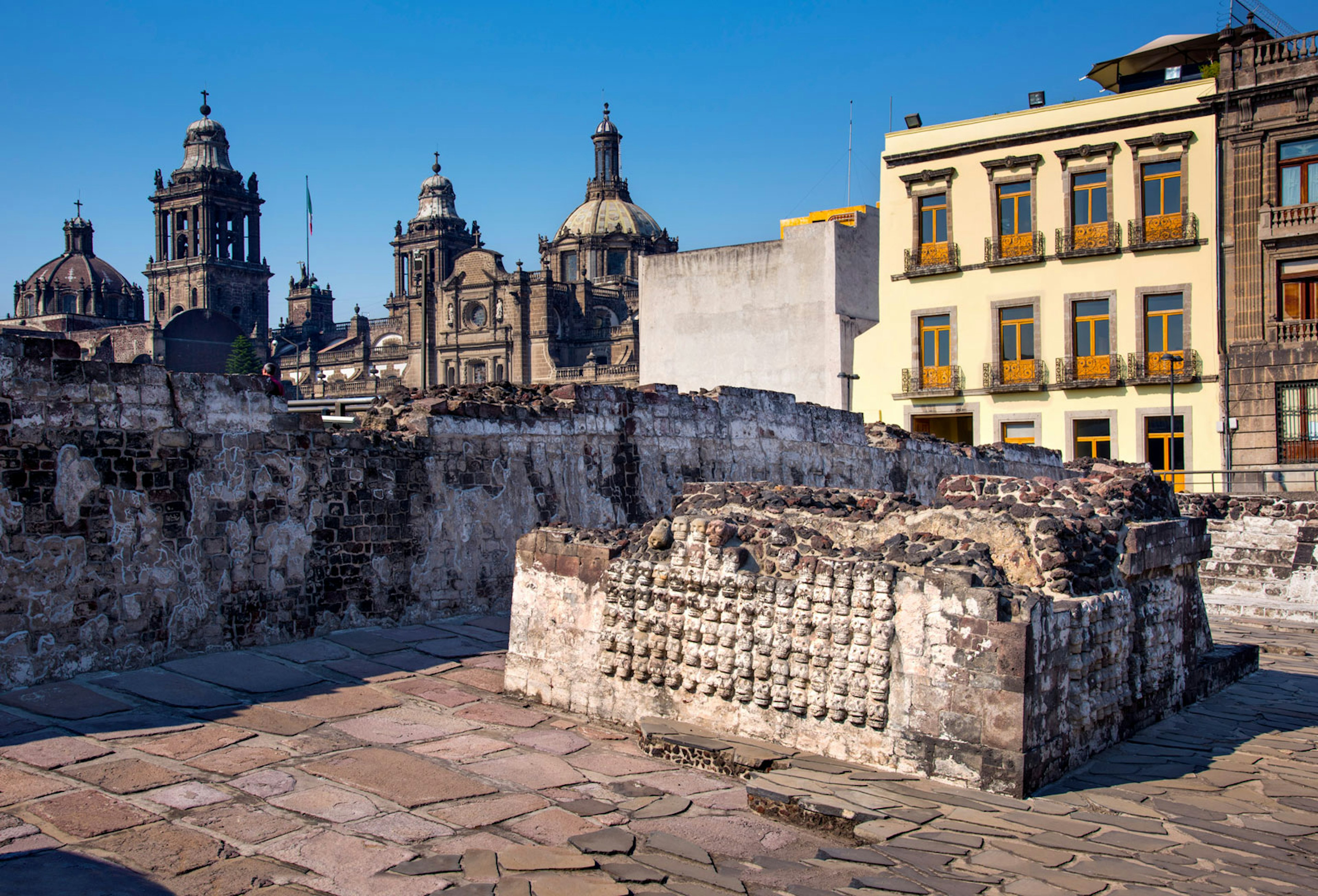 A skull adorned piece of a former alter is in the foreground with the cathedral in the background