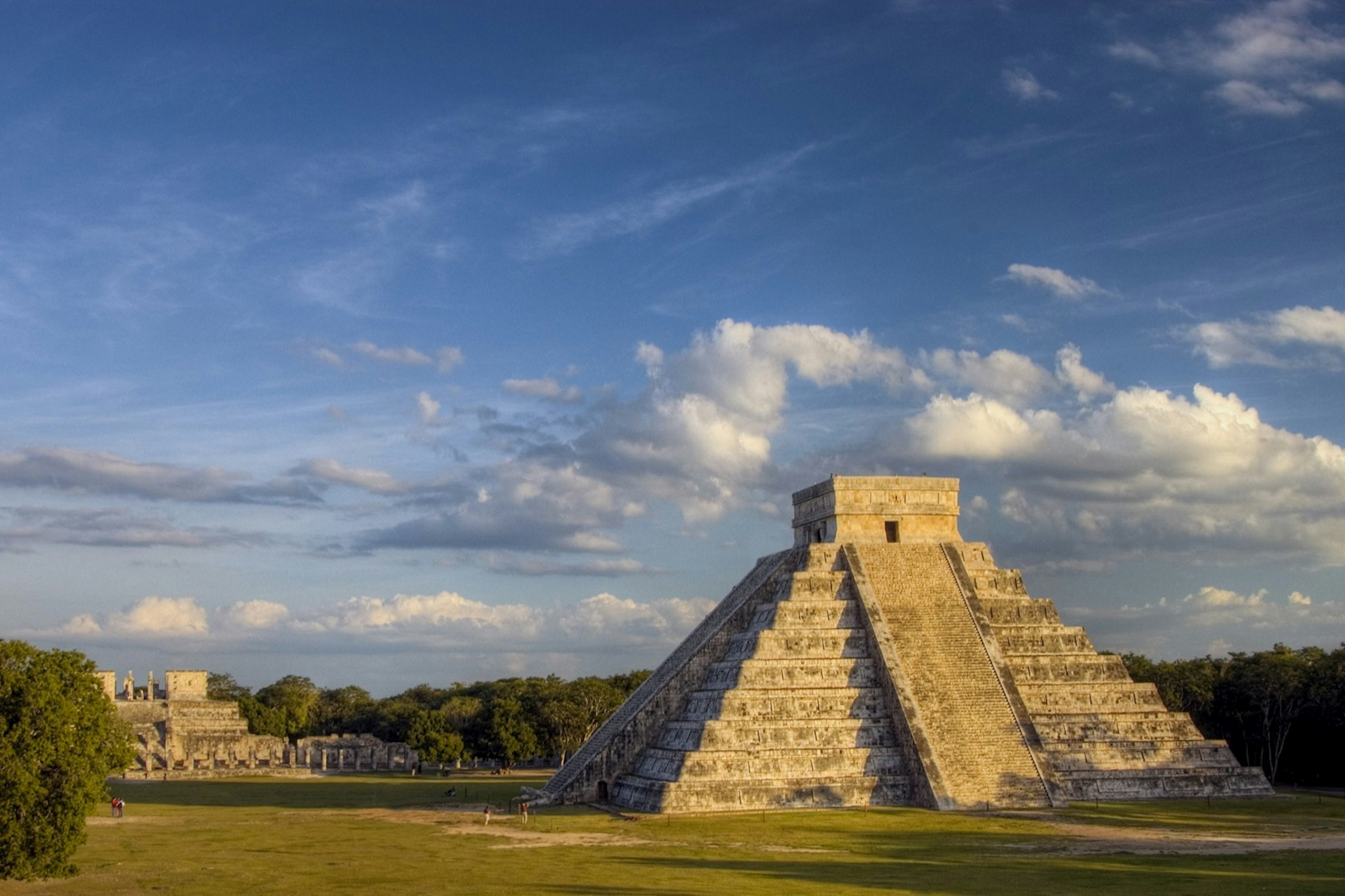 A Mayan pyramid during the golden hour with a blue sky