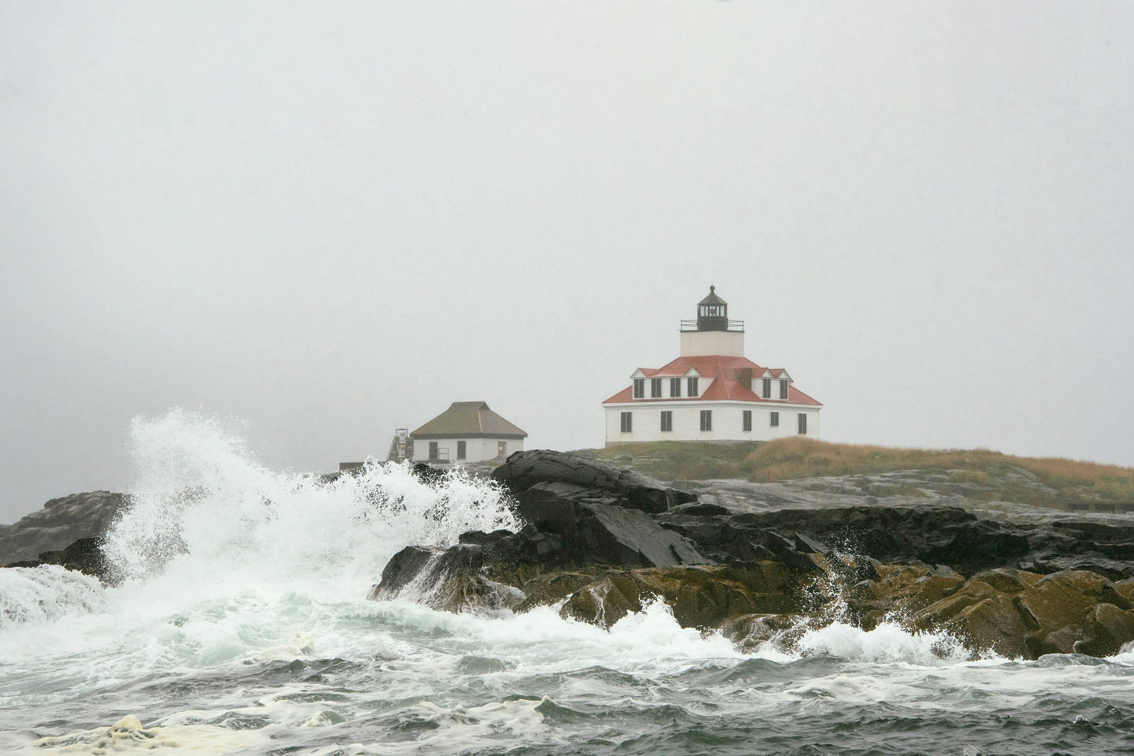 Waves break on the rocks next to Egg Rock Light