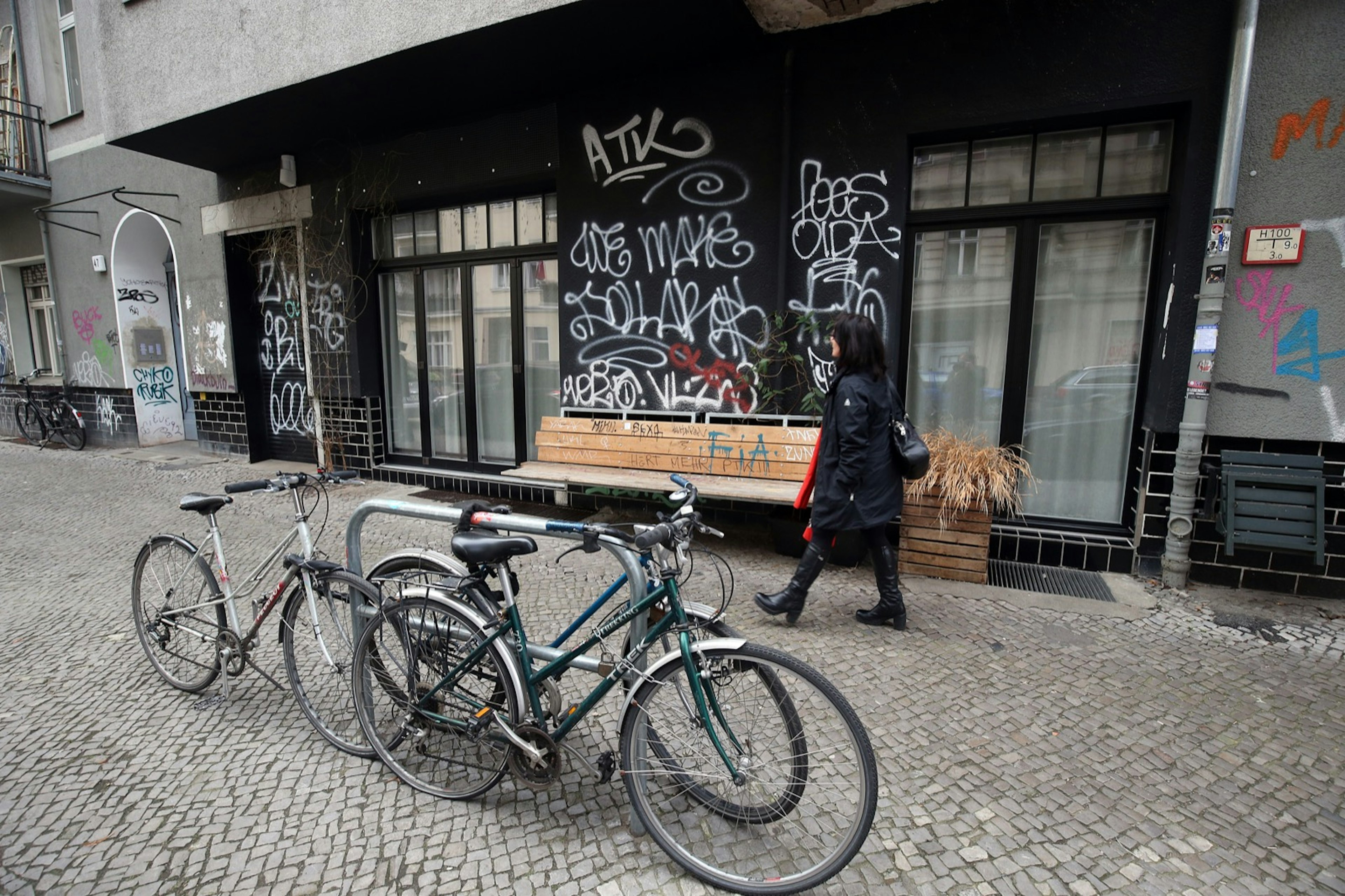 Facade of Coda dessert restaurant painted black with white graffiti and bikes out front