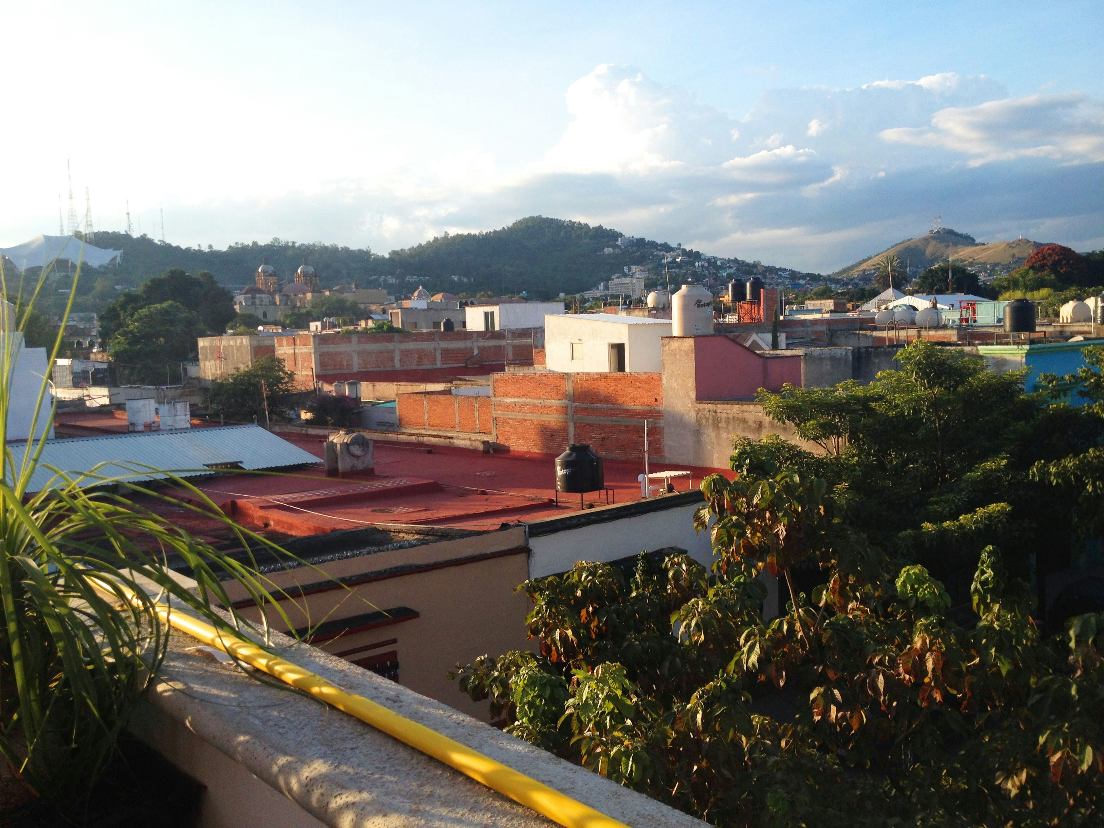 the view from the rooftop patio of Comala with the rooftops of Oaxaca and a mountain in the background