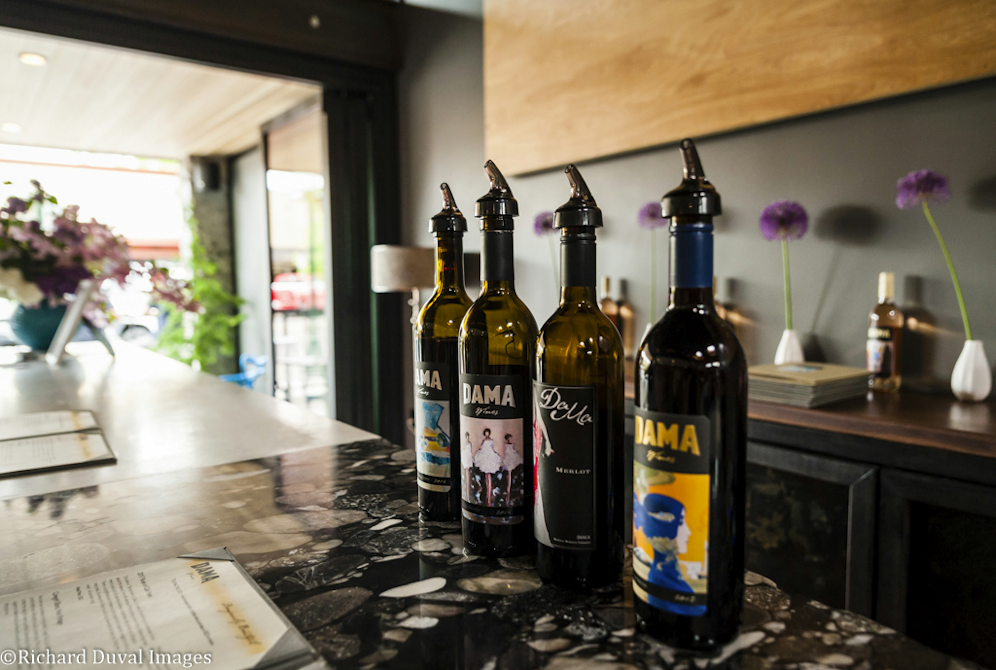 A row of bottled wines sit on a bar; Walla Walla wines