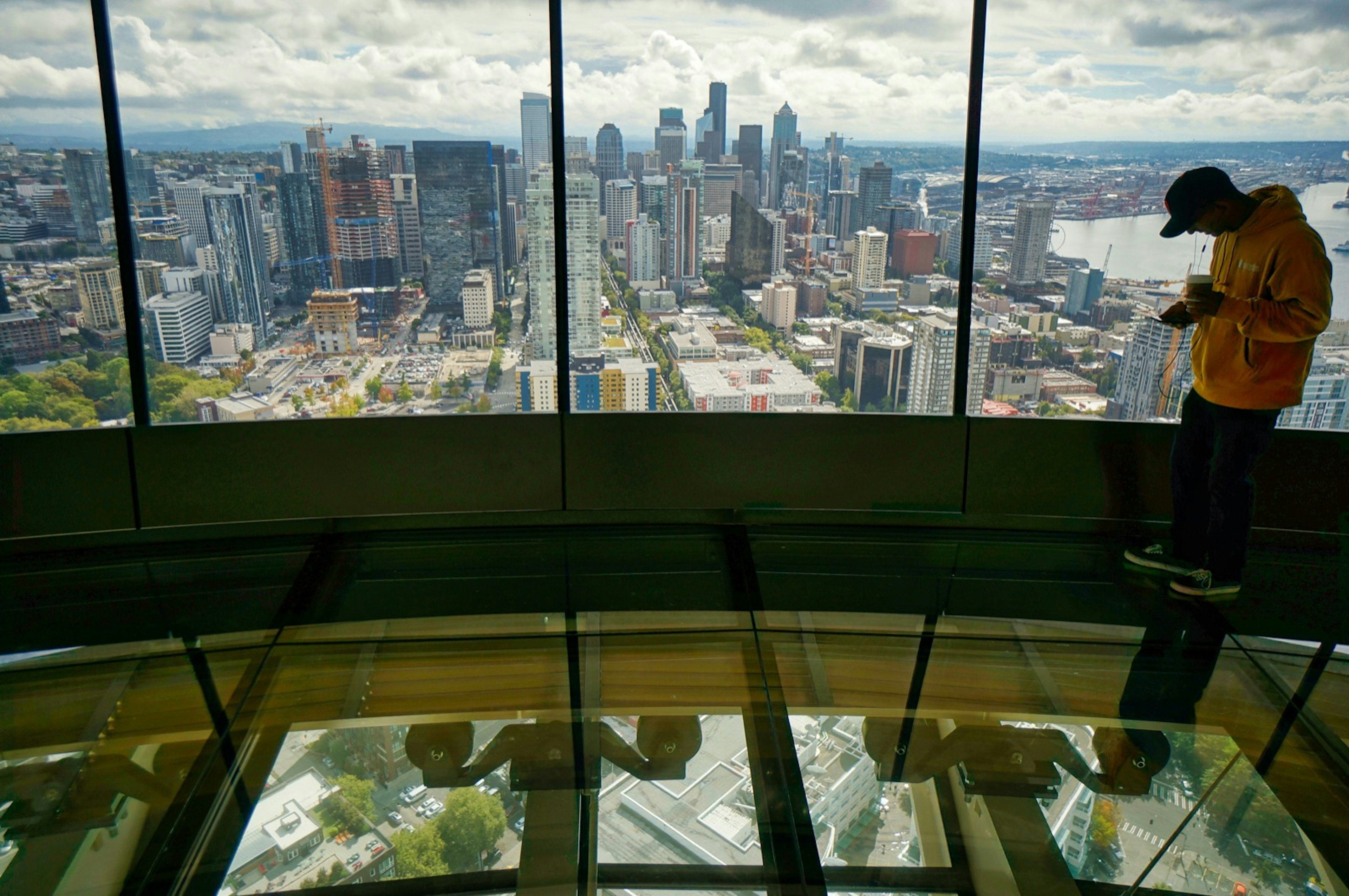 A man takes a picture with his camera phone through the clear glass floor of the Space Needle