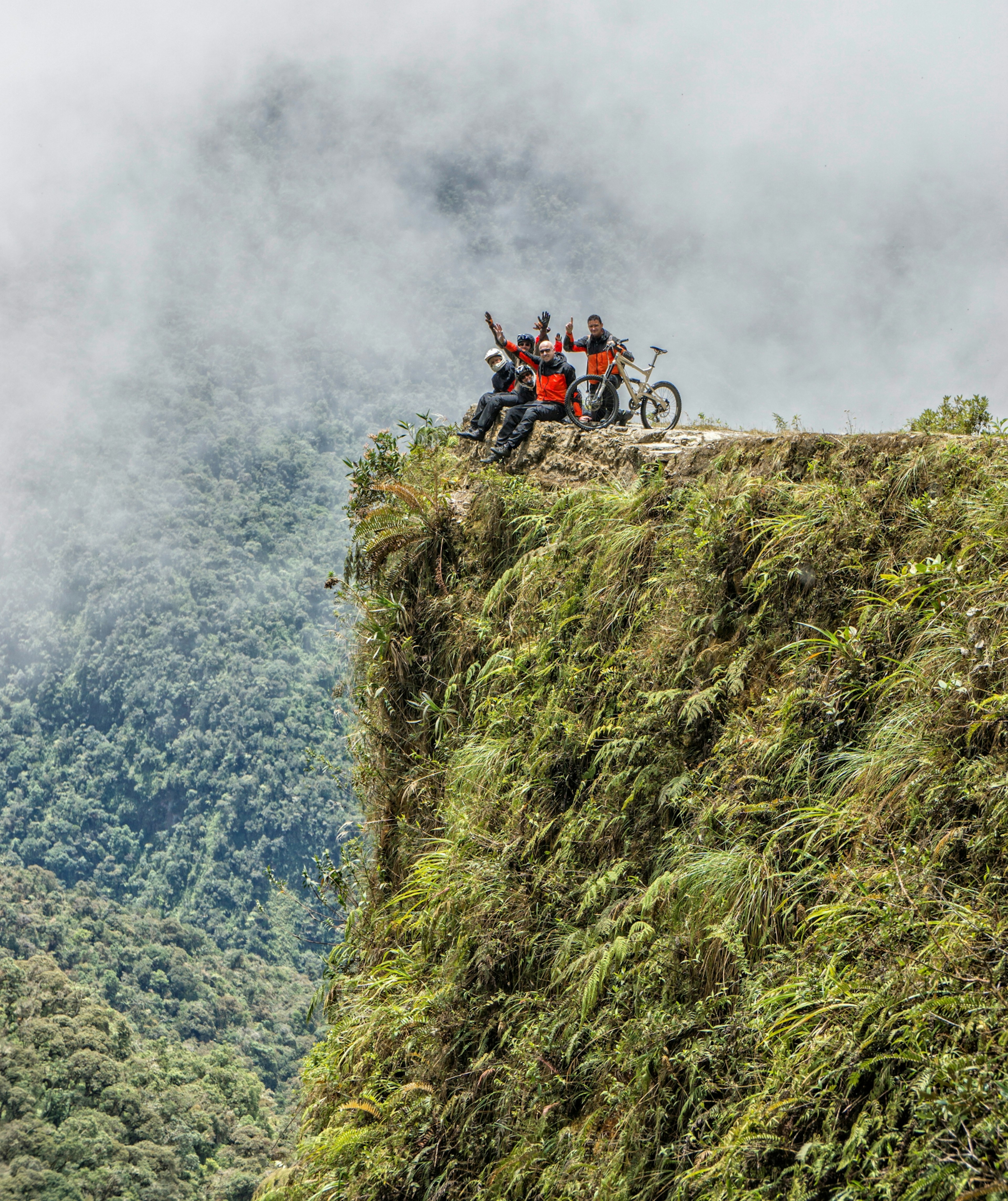 Mountain bikers pose for a picture next to a sheer drop along the downhill run of the Yungas Road © mezzotint / Shutterstock