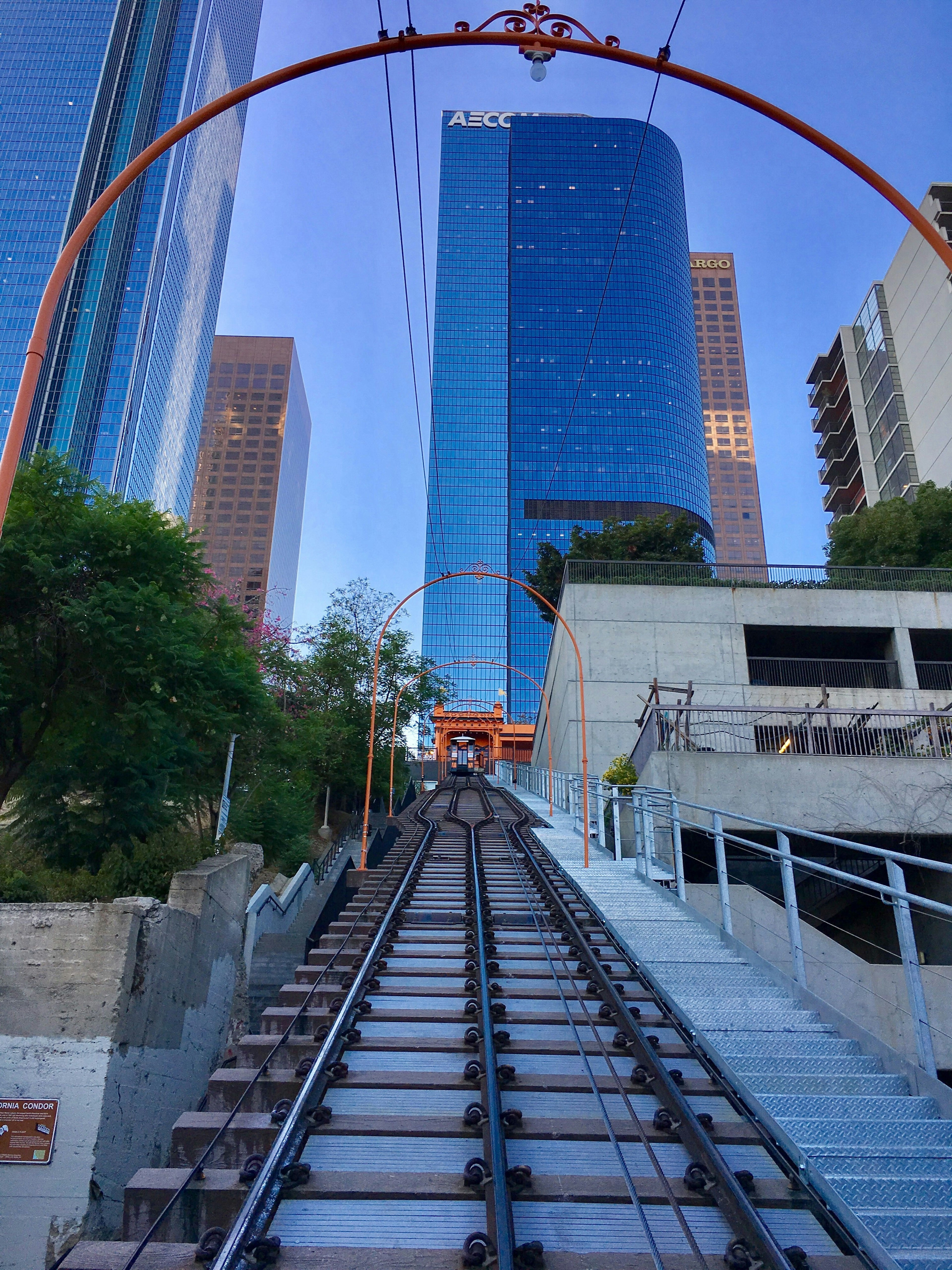 Modern city against a clear sky with train tracks and orange arches