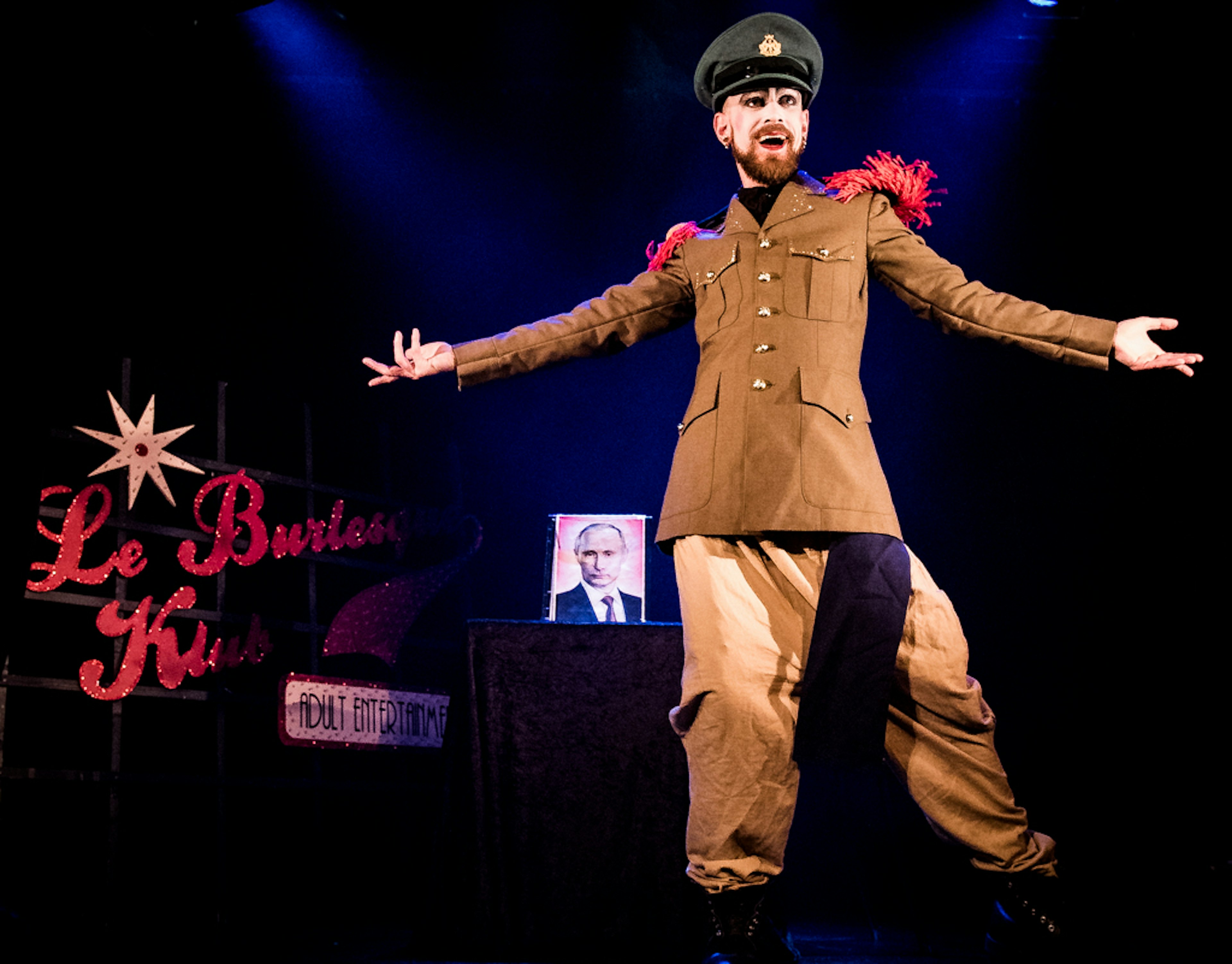 Performer Tom de Montmartre dons soldiers' garb to perform a satirical act to a photo of President Putin at La Nouvelle Seine