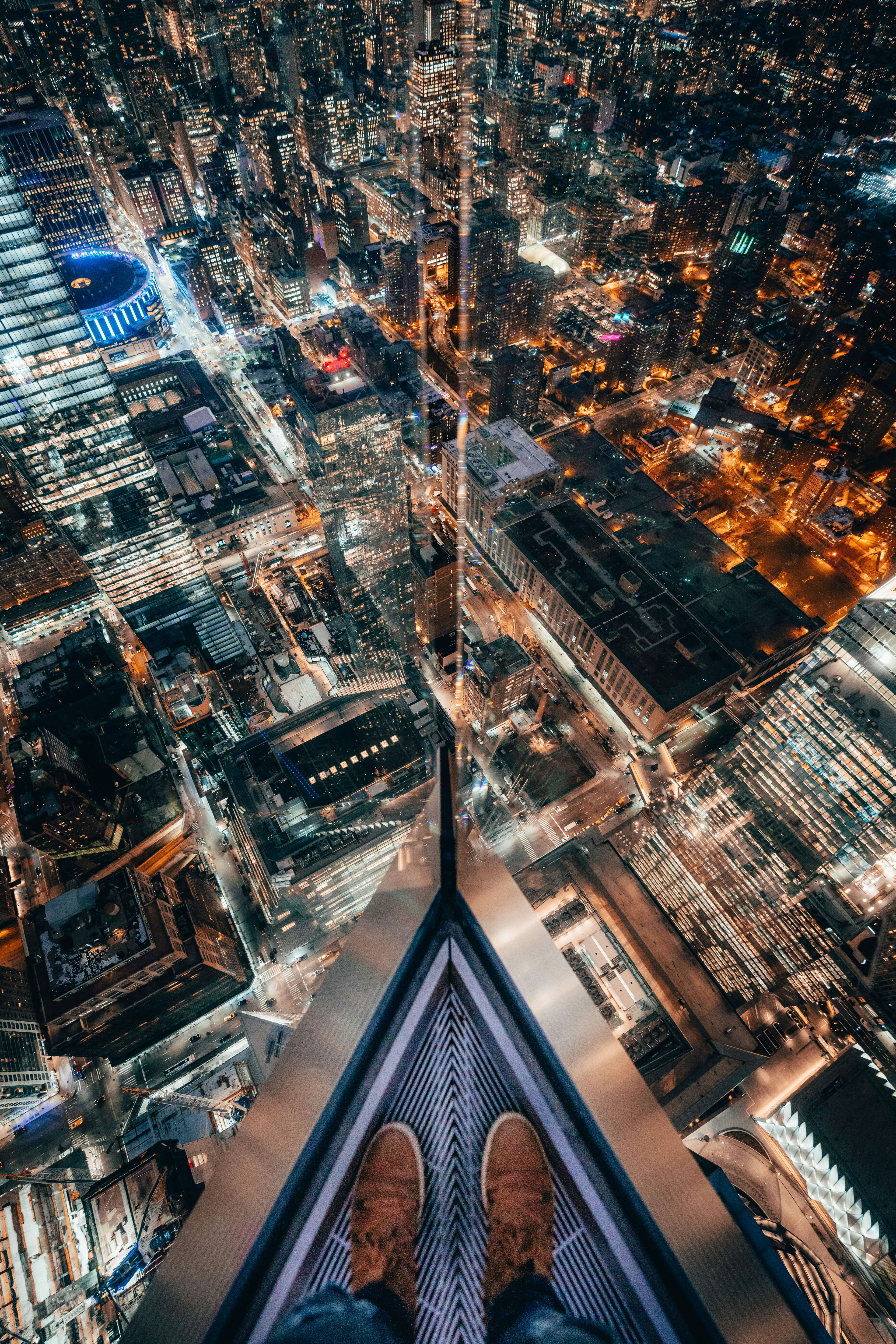 A view of a person's feet standing at the Edge's eastern point overlooking the city