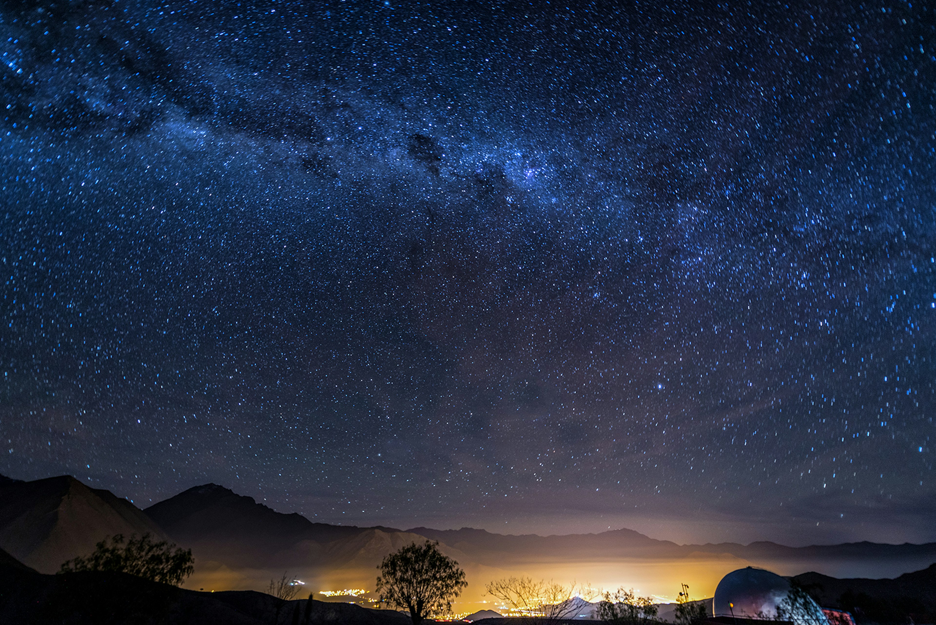 A long-exposure photo of the Milky Way over the lights of the Elqui Valley © Jesse Kraft / EyeEm / Getty Images