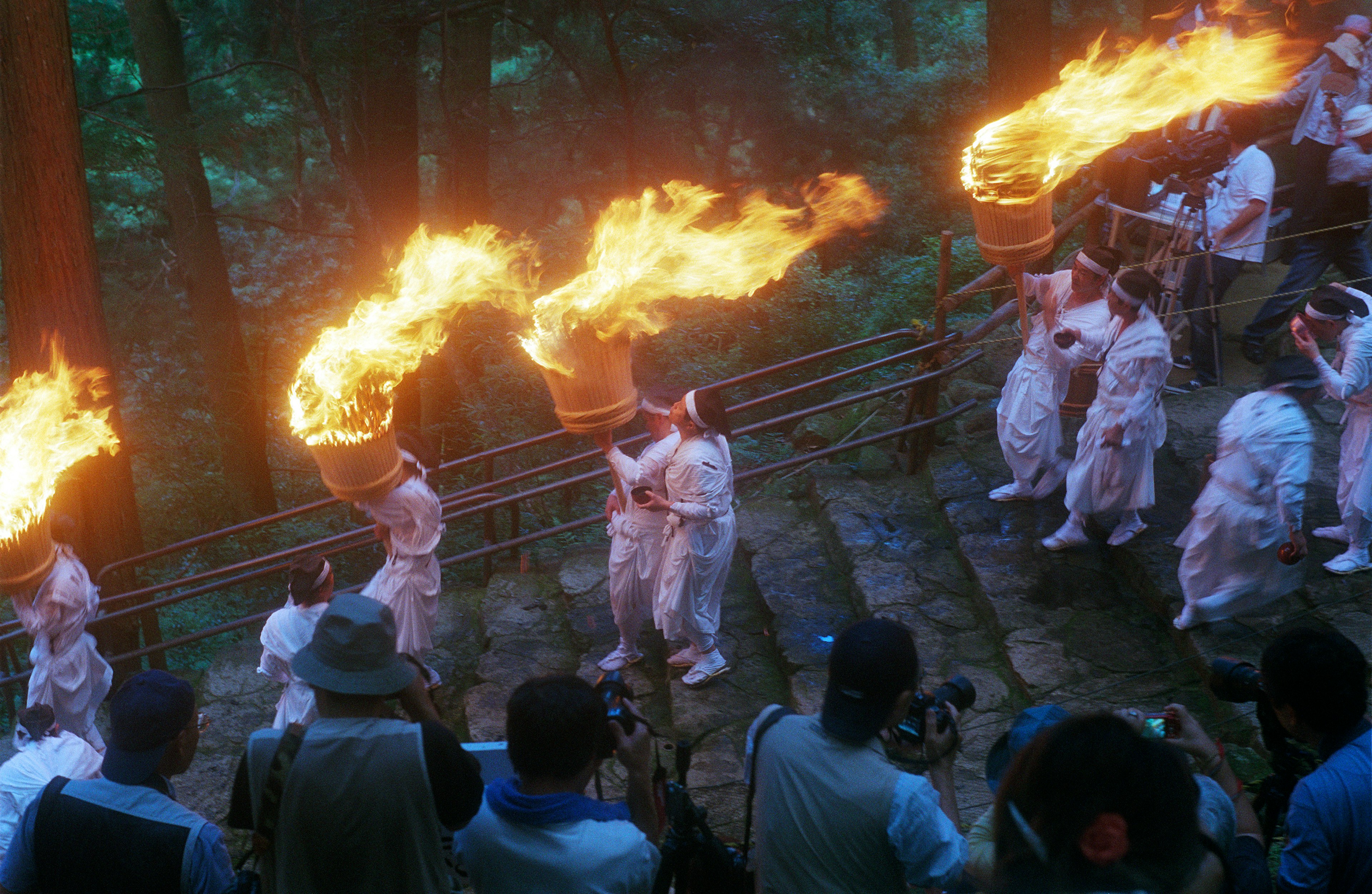 Nachi, Wakayama, Japan - July 14, 2011: Festival participants dressed in white walk down the stairs of a mountain holding flaming wooden torches. A man attempts to blow out the fire from a torch using water from his mouth.
502898564
Nachi Falls, Wakayama Prefecture, Weather, Shinto, Japan, fire festival, White Clothing