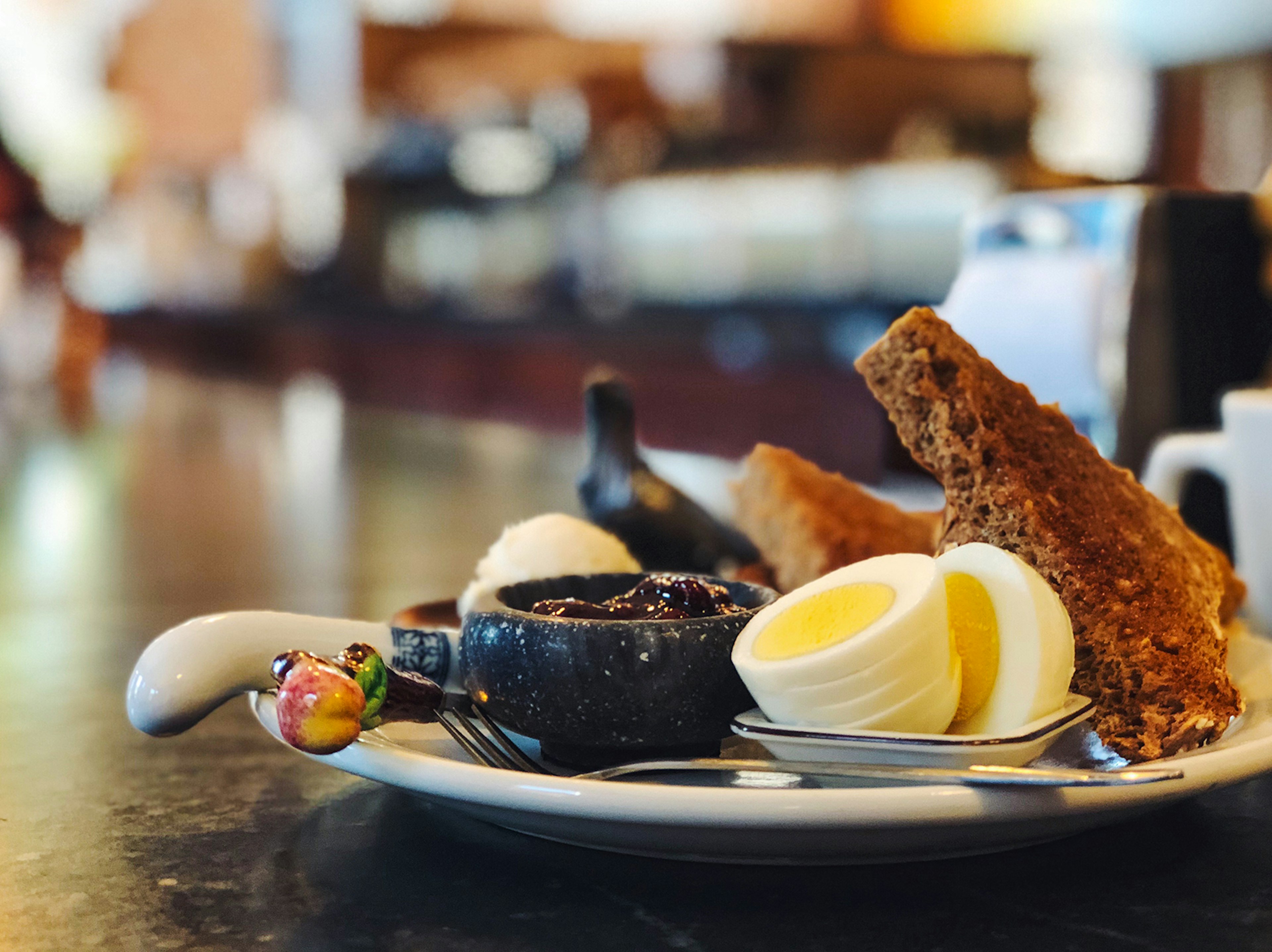 A side view of a plate filled with toast, jam and a sliced hardboiled egg at Five Point Bakery. Buffalo, NY.