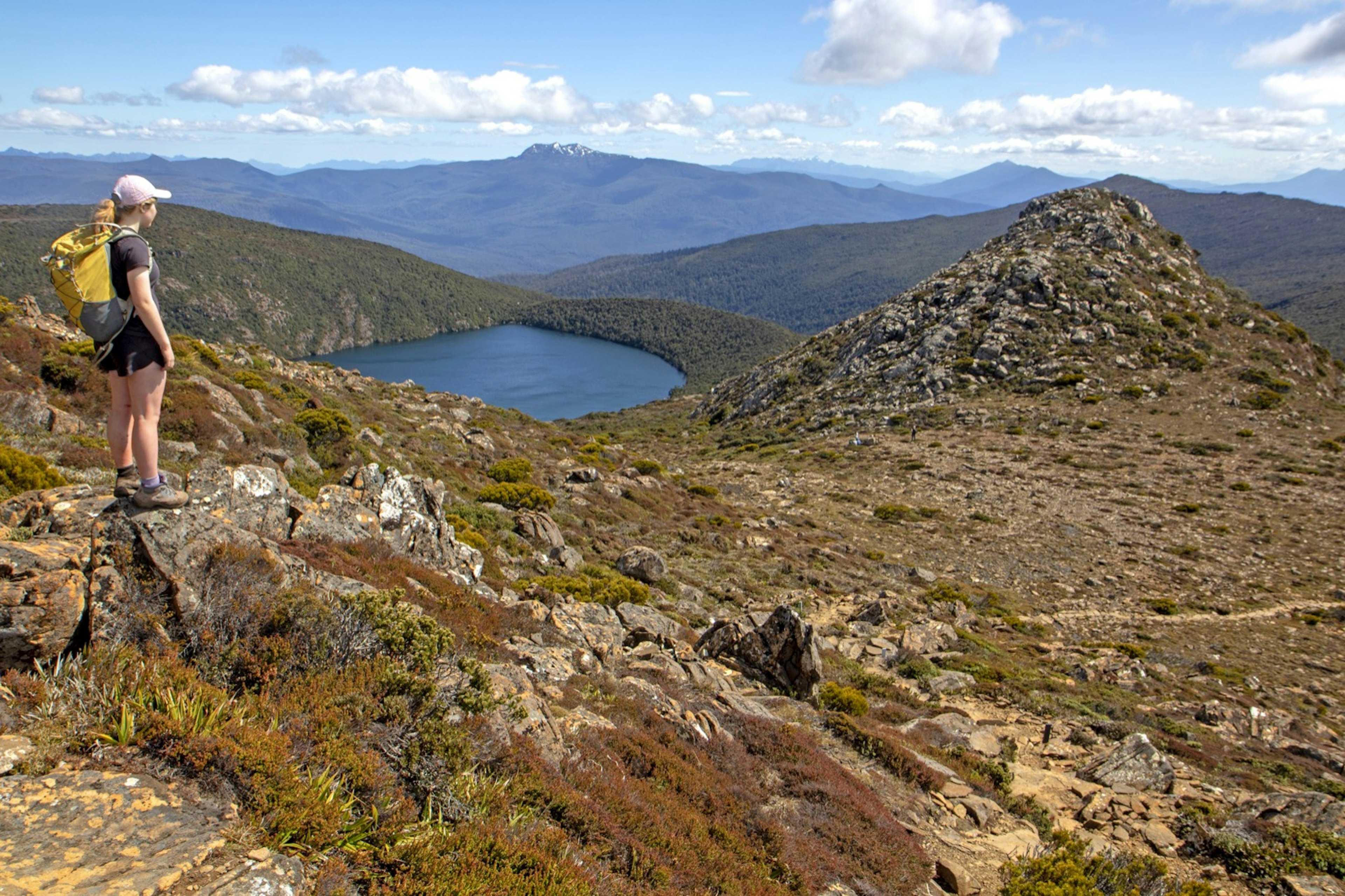 A girl stands on the slopes of the Hartz Mountains looking to Hartz Lake