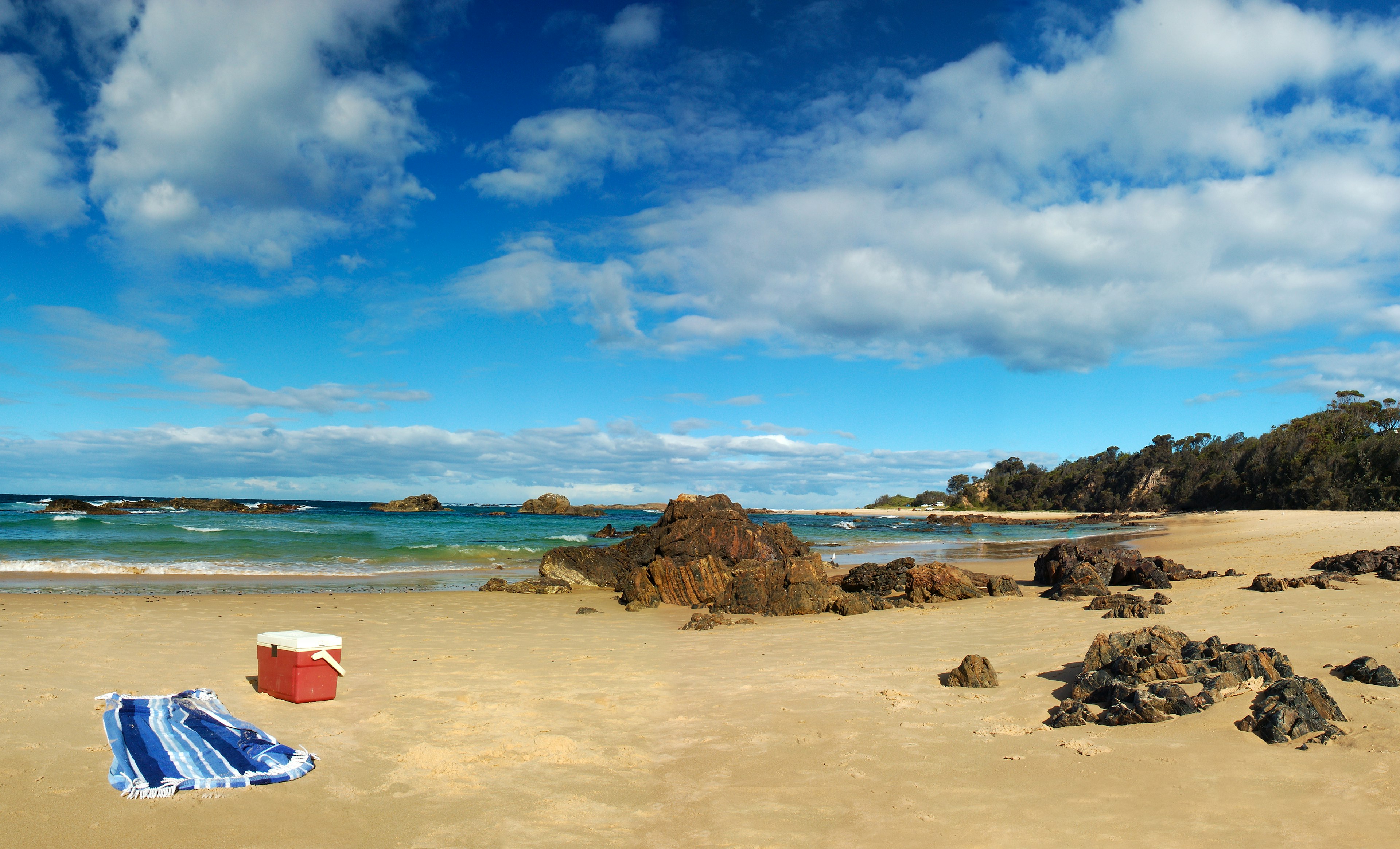 An empty cooler sits on a beautiful beach