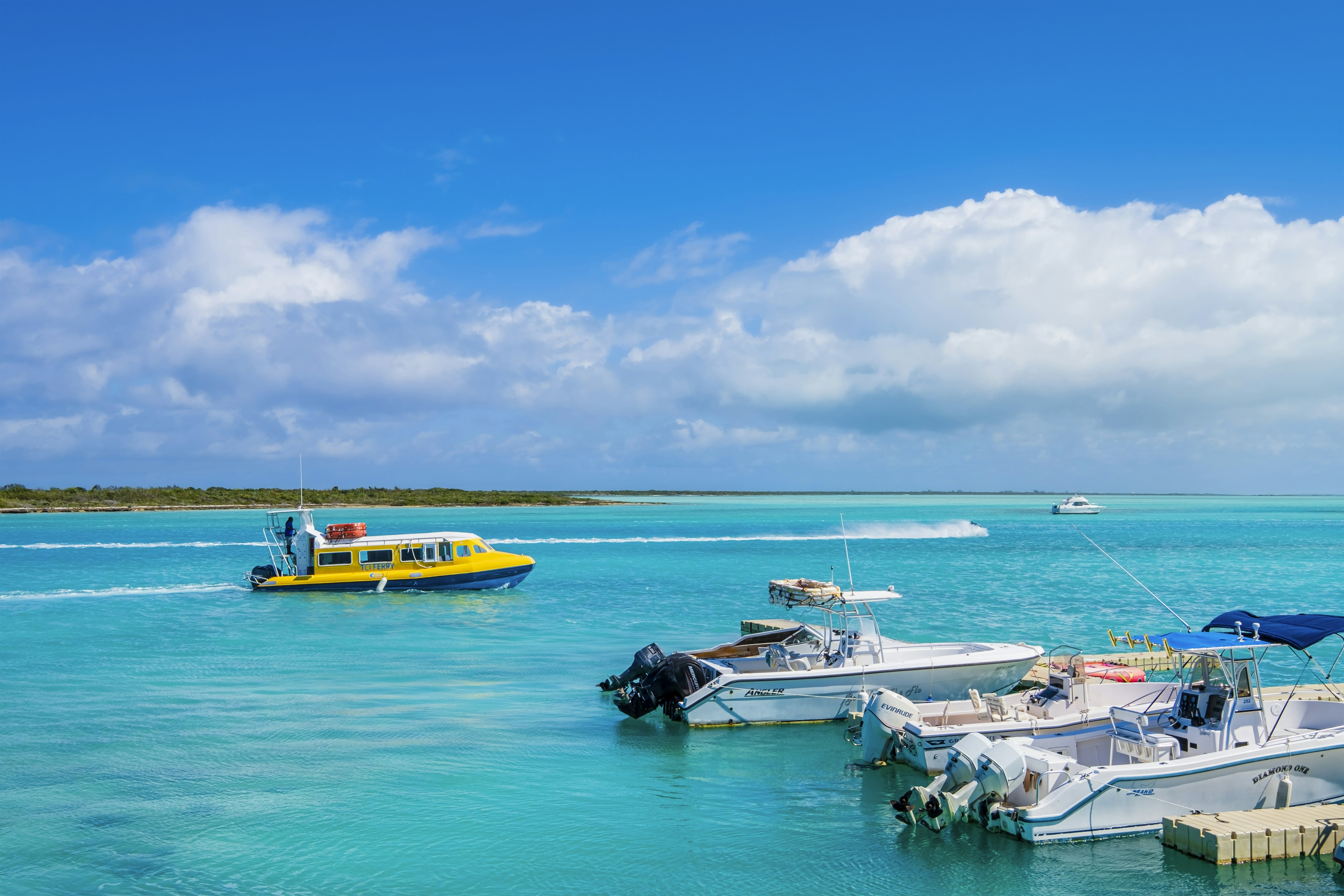 A small yellow ferry boat shuttles out to sea, while several small speedboats are docked in the foreground. | Be sure to plan your travel carefully, especially if you're using the limited ferry service. Flavio Vallenari/Getty Images