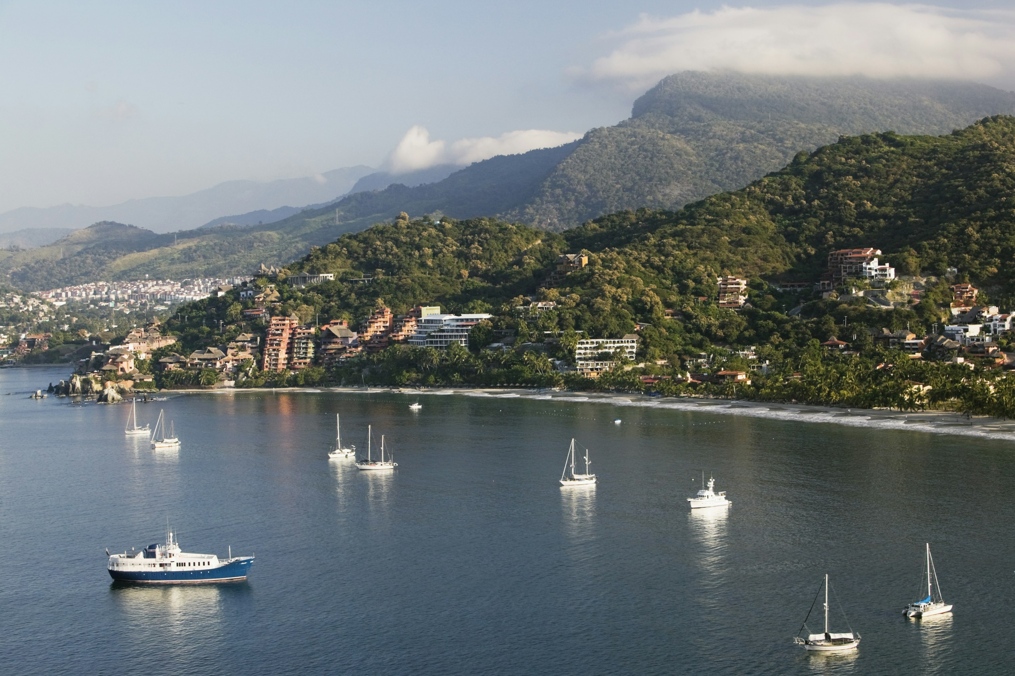 Sail boats and yachts dot the bay in Playa La Ropa © Walter Bibikow / Getty Images