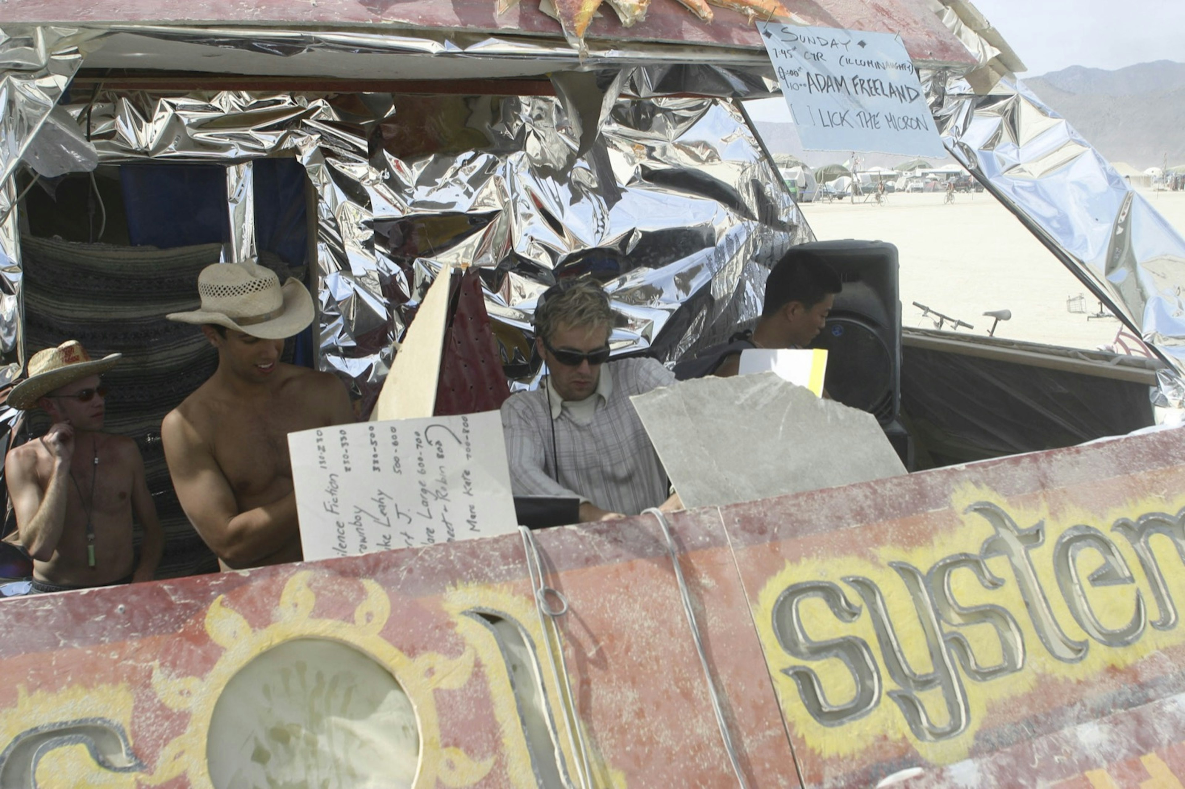 a man spins records in a rolling contraption in the desert