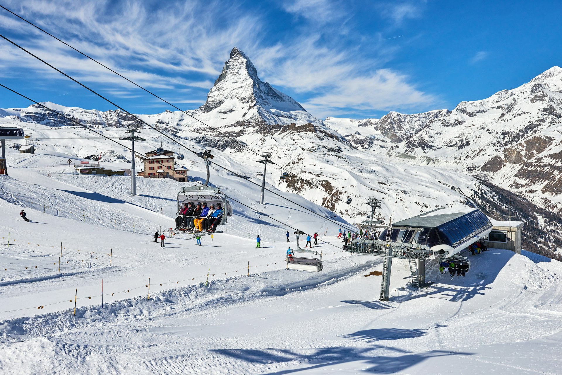 People are on chair lifts leaving a lift station, which has the Matterhorn in the background, in Zermatt, Switzerland.