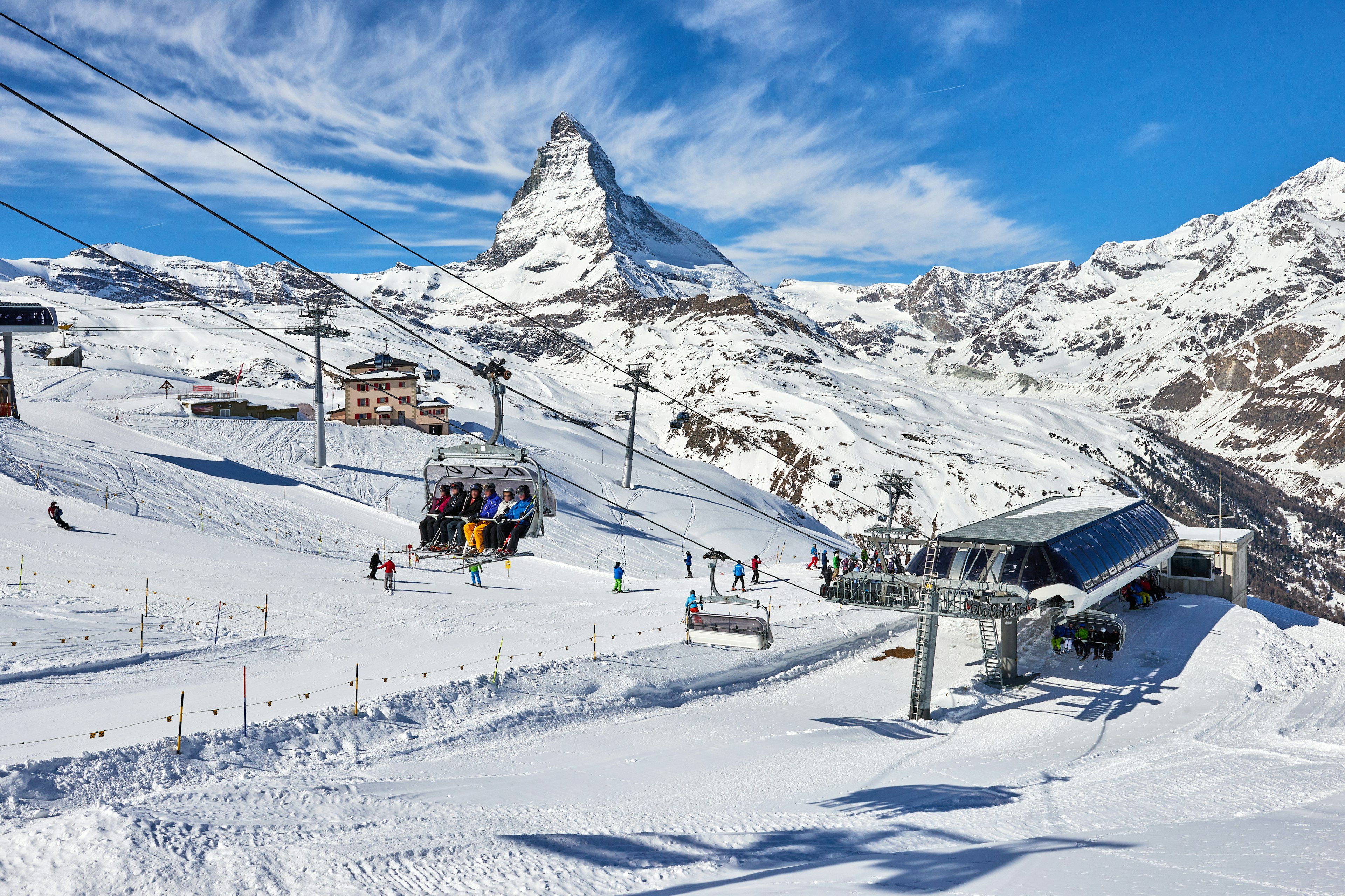 People are on chair lifts leaving a lift station, which has the Matterhorn in the background, in Zermatt, Switzerland.