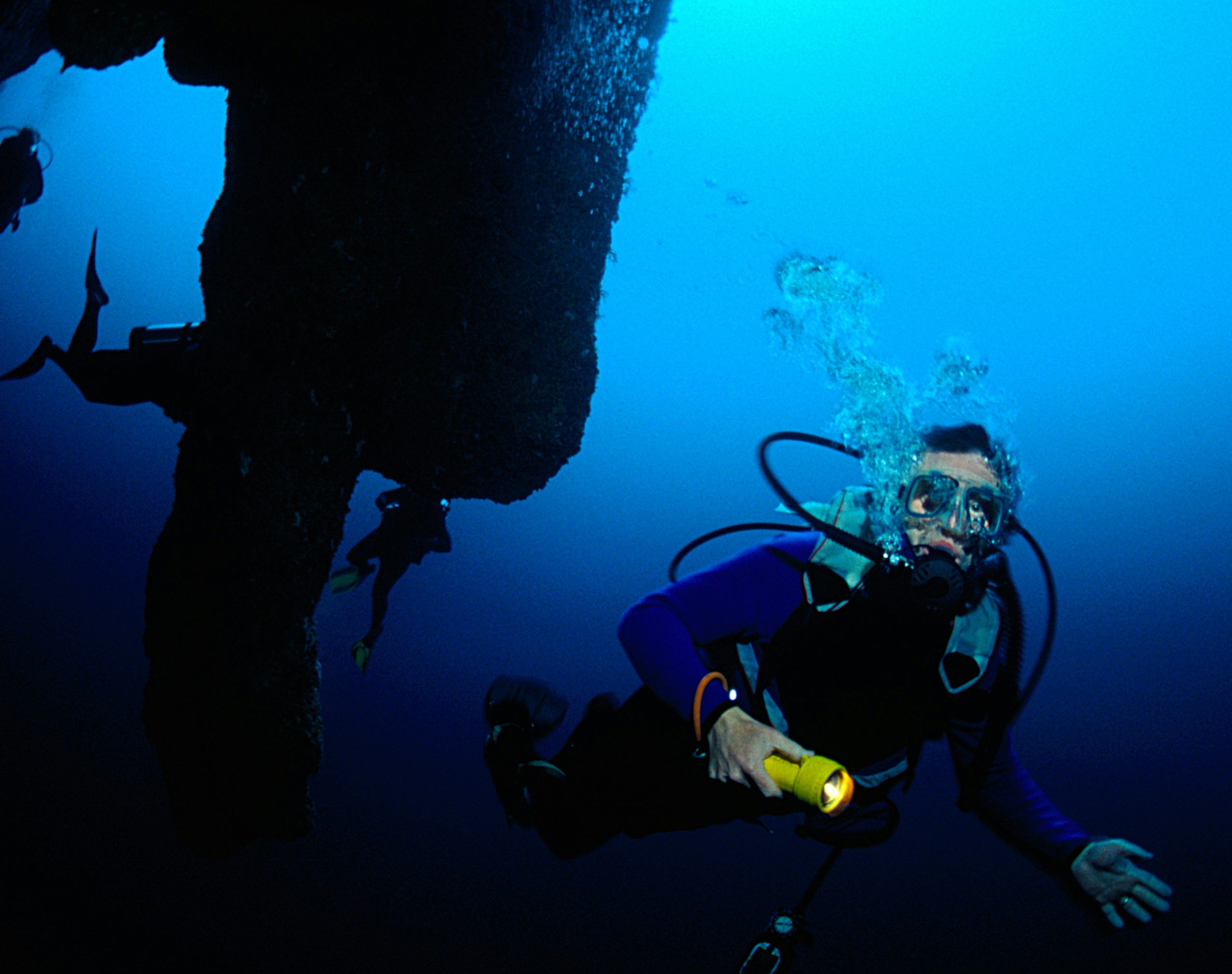 Exploring the stalactites of the Great Blue Hole. Image by Mark Webster / Getty