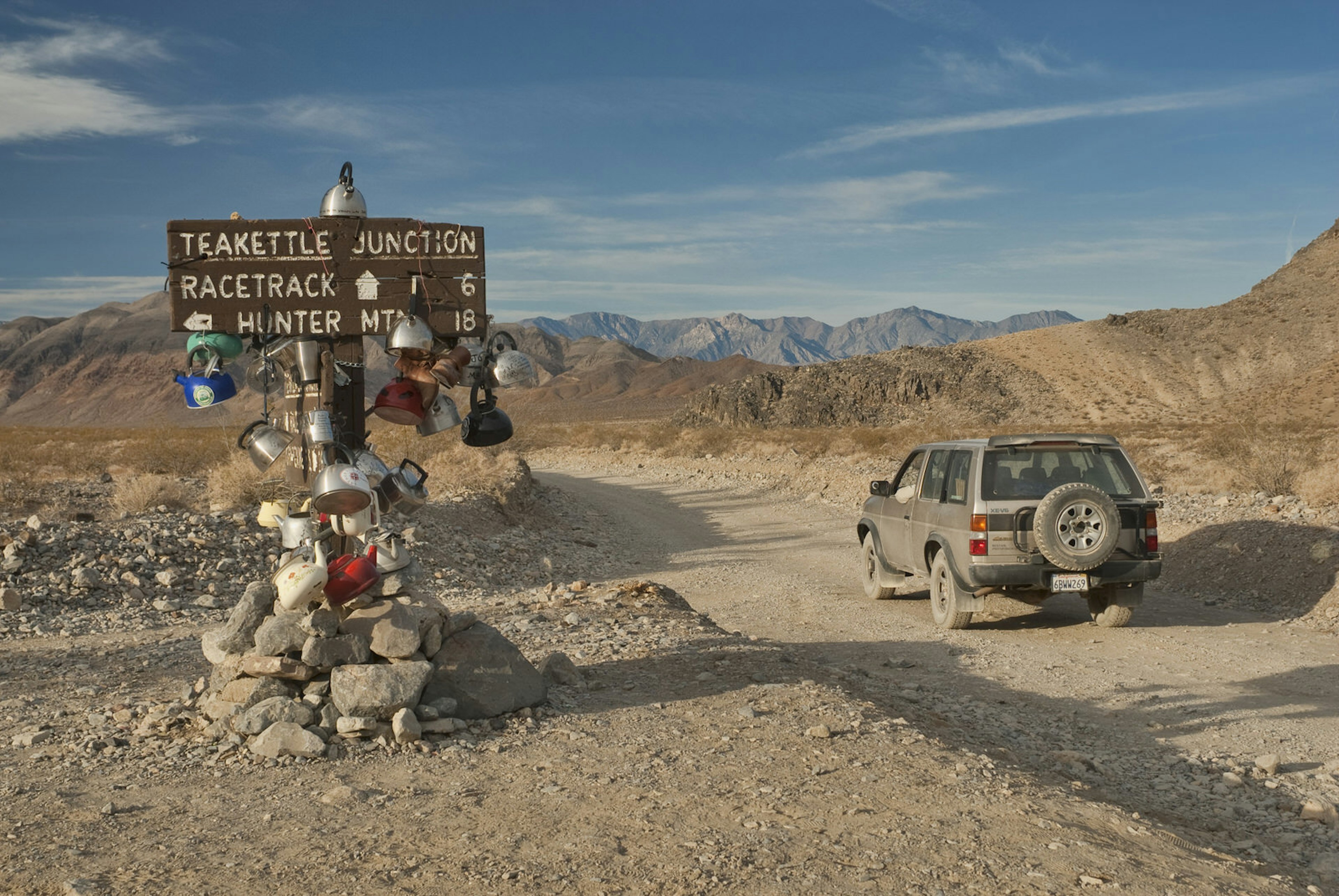 A jeep drives past Teakettle Junction in Death Valley National Park, California, USA © Witold Skrypczak / Getty Images