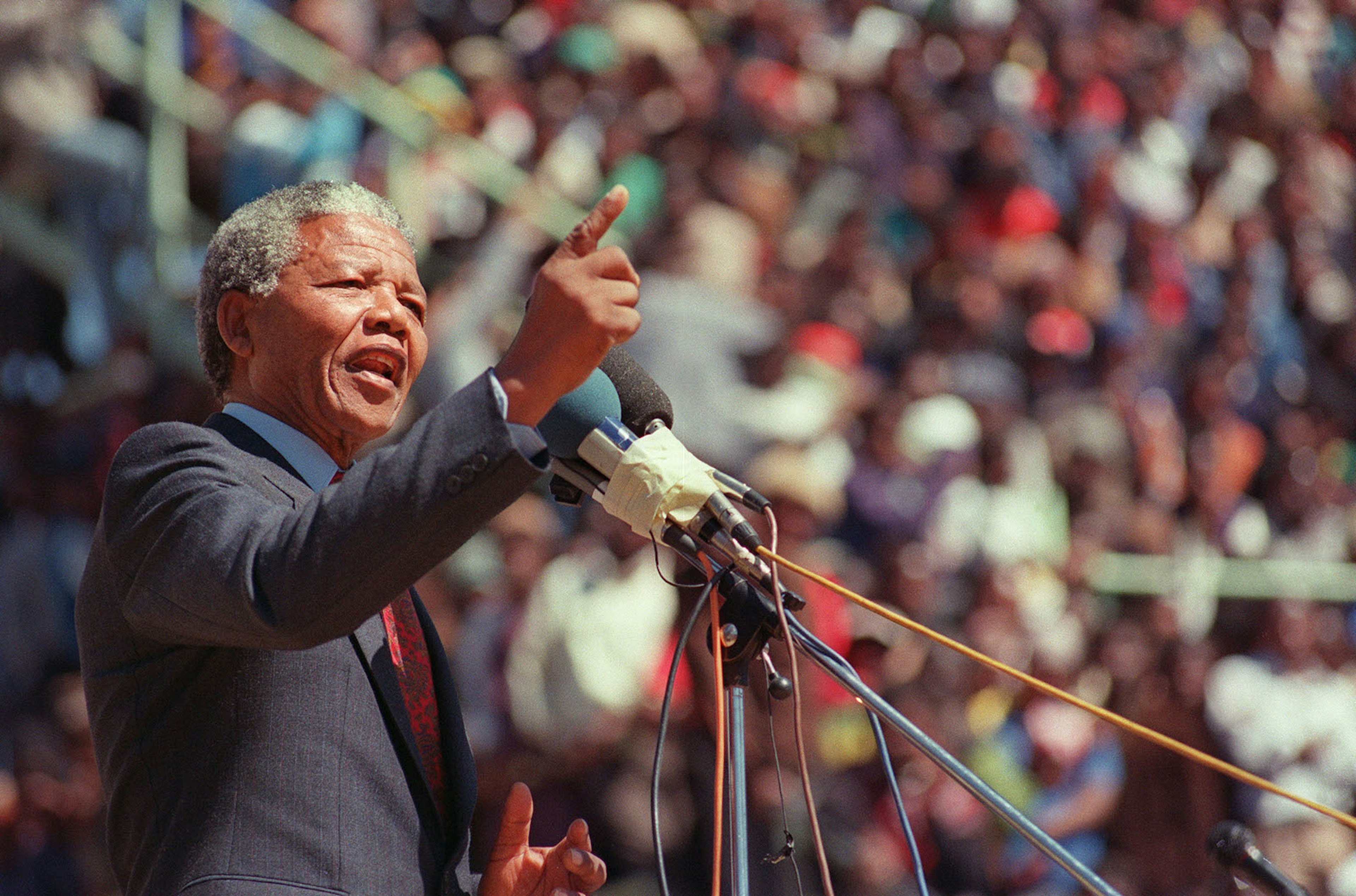 Nelson Mandela makes a speech to a colourful crowd at a funeral in Soweto, South Africa in 1990 © ALEXANDER JOE / Getty Images