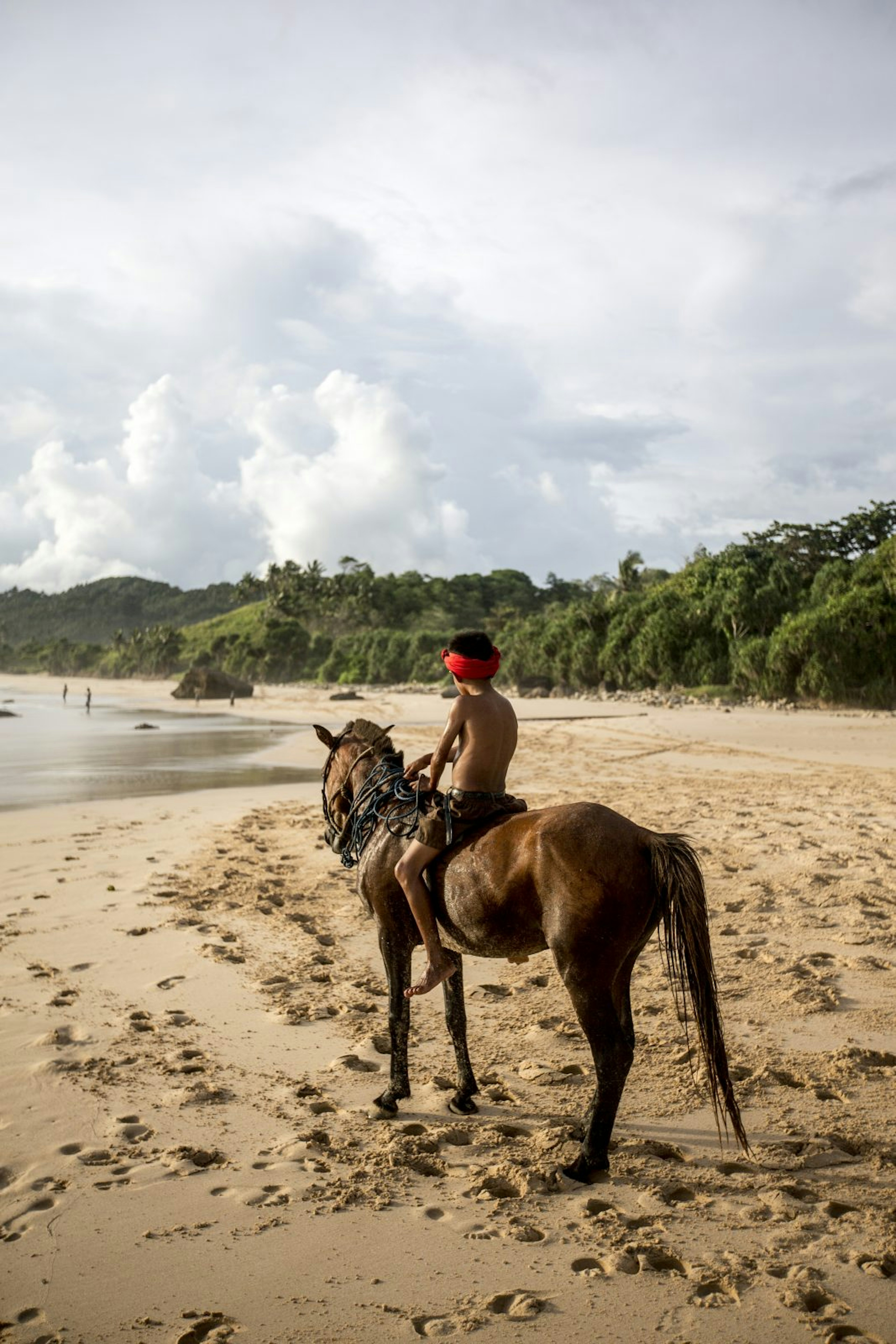 A young boy with his horse in Nihiwatu, Sumba. Horses play an important role in Sumbanese culture and distinguish Sumba from the rest of Indonesia.