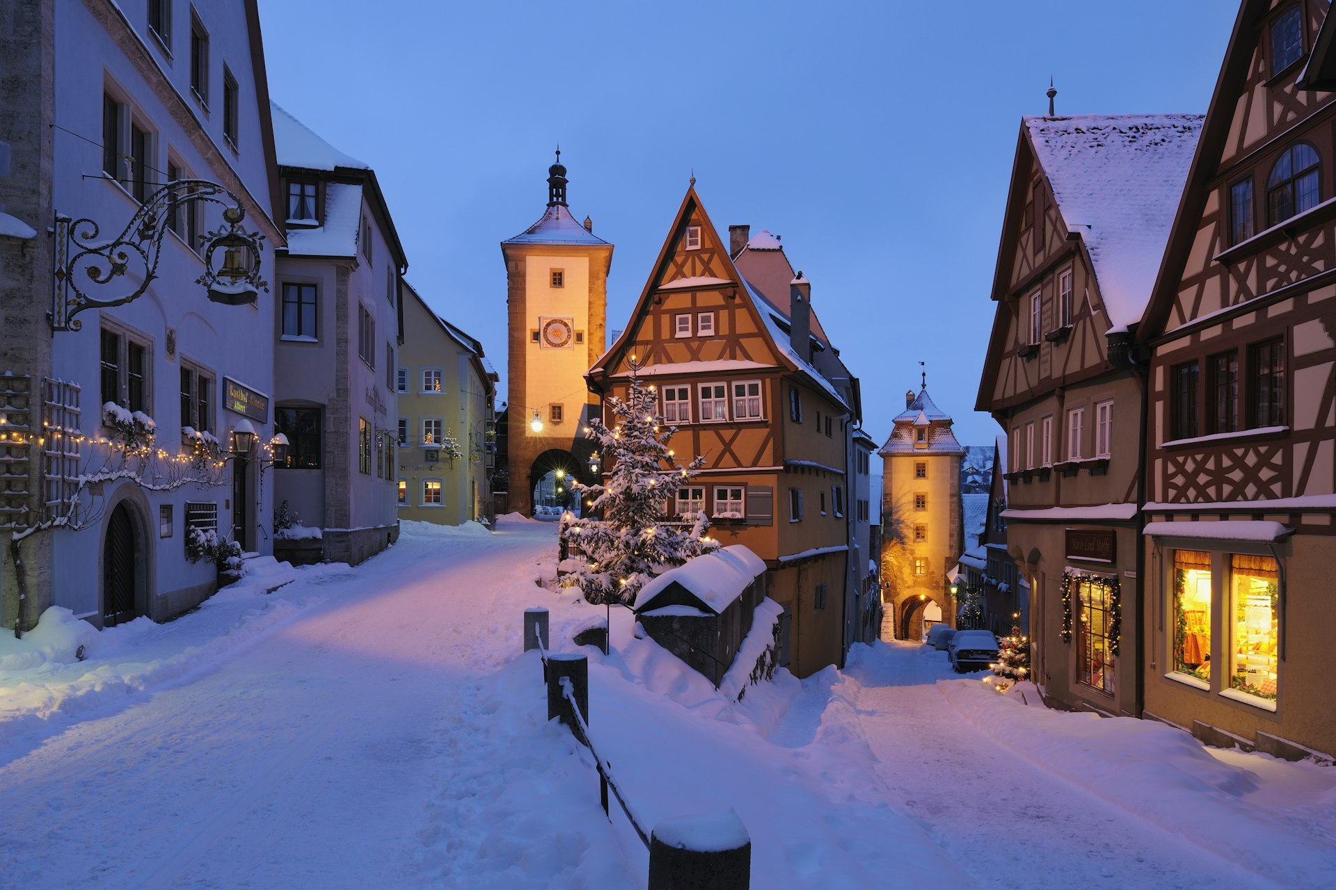 Snow blankets the streets in this view of the Sieber Tower and Kobolzeller Tower in historic Rothenburg ob der Tauber, Bavaria