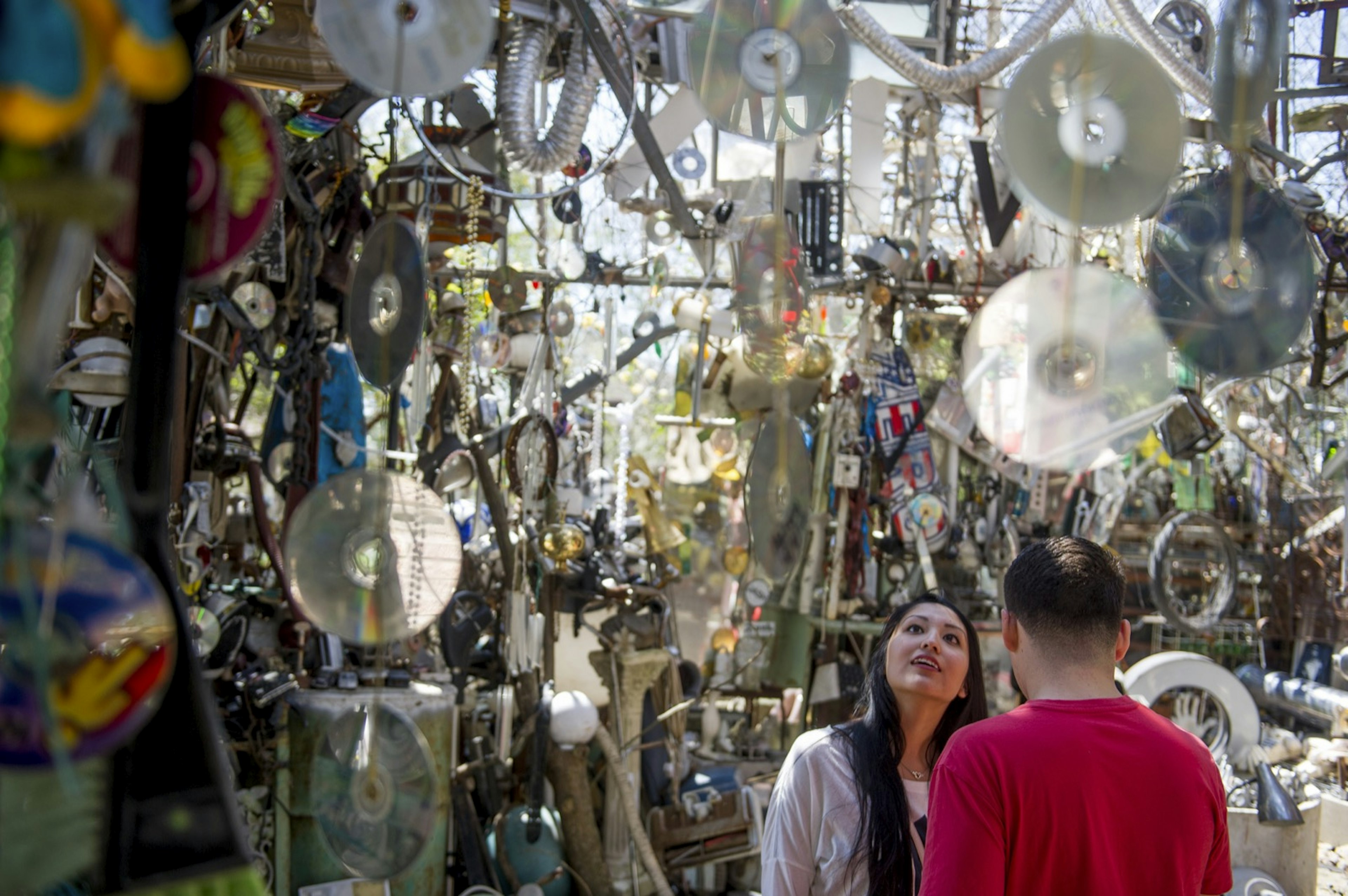 CDs and other random junk form a glittering structure as people walk through and look in Austin Texas