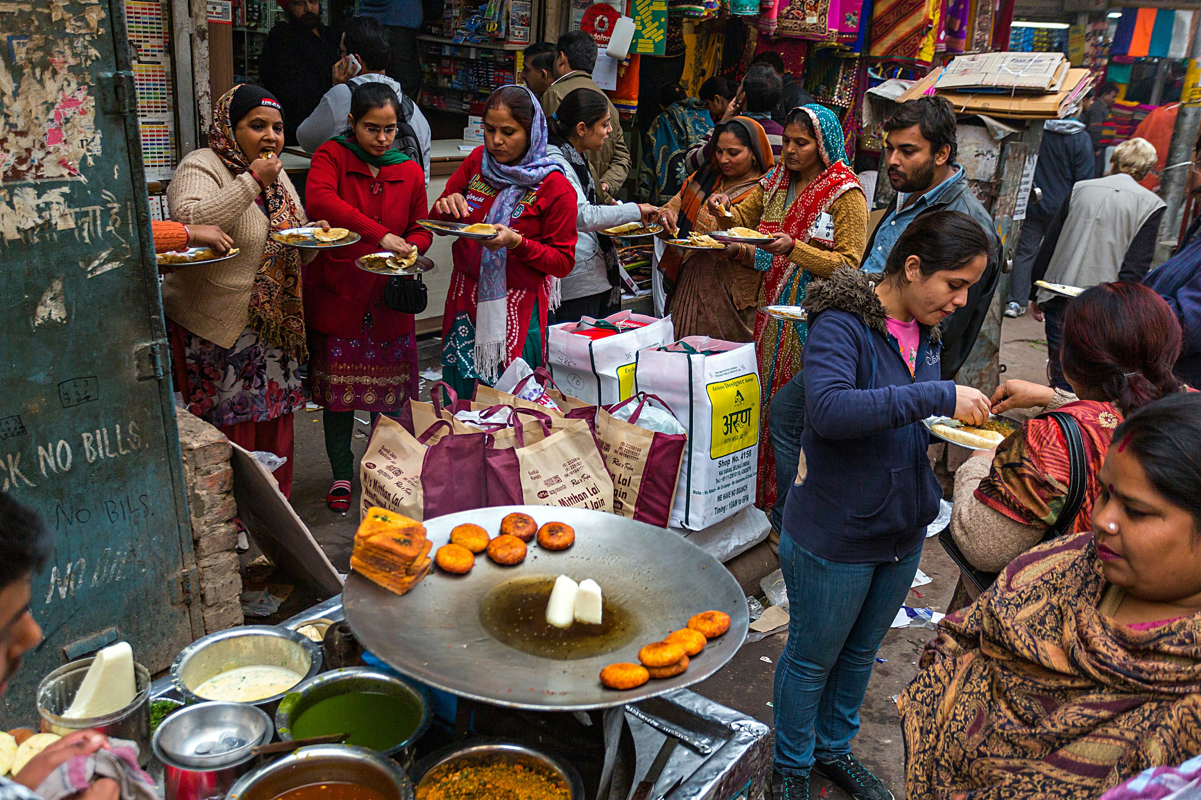 Women gather in a Delhi market for a street food snack