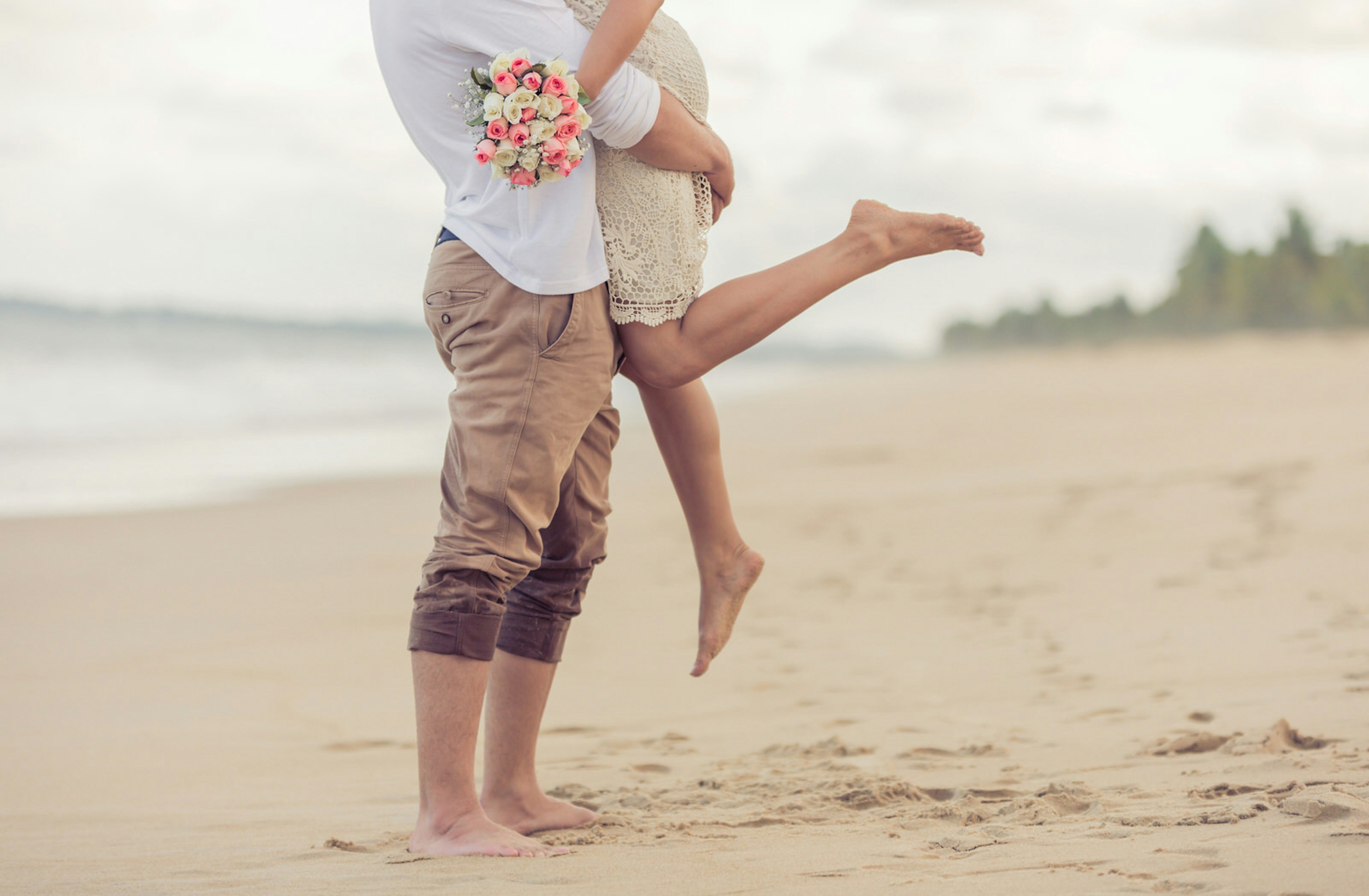 A couple embrace on the beach.