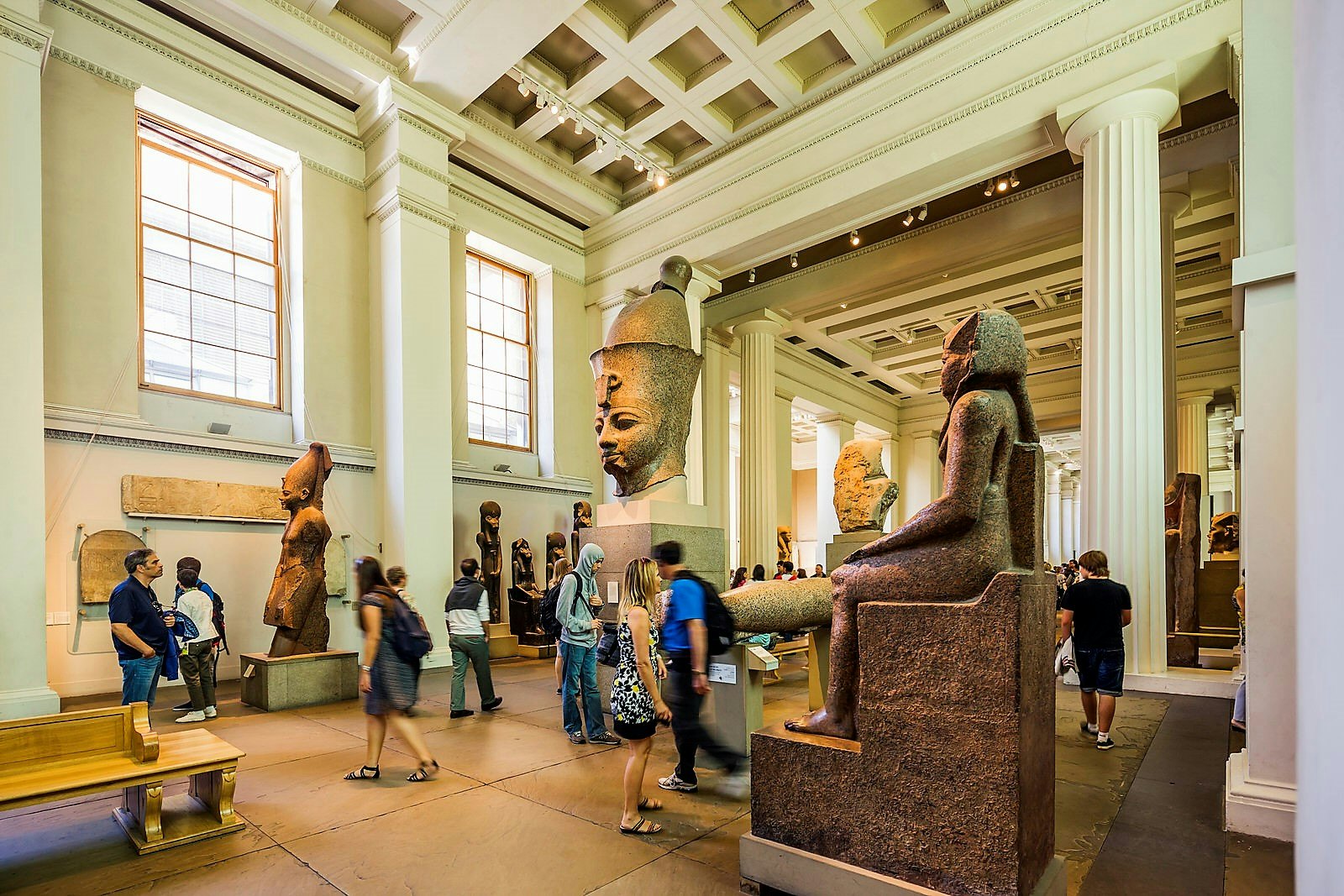 Visitors wander between statues in the British Museum's Egyptian sculpture gallery