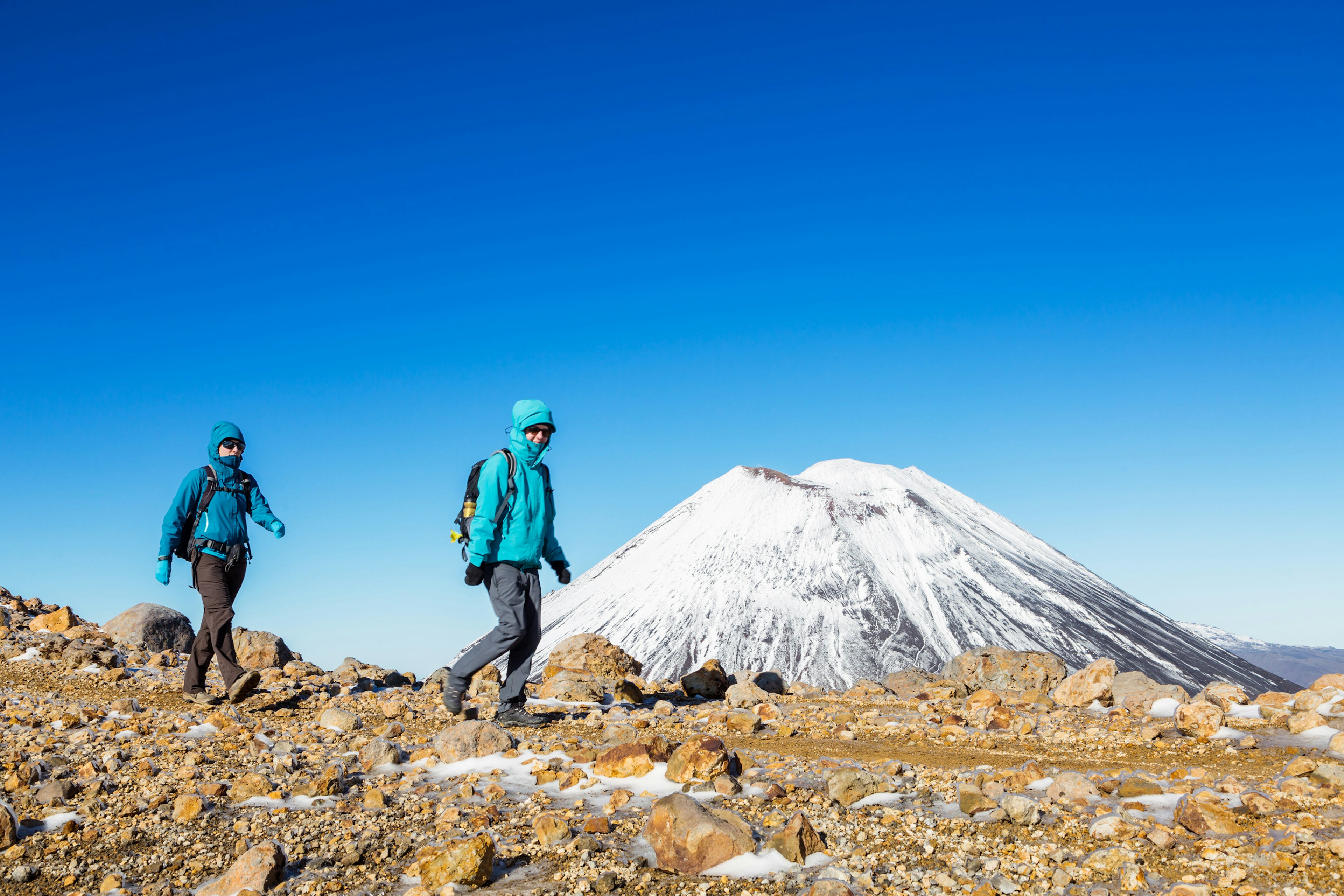 578363193
adventure, exploration, hiking, vacations, tongariro crossing
Two female hikers walking near Mt. Ngauruhoe volcano (Mt Doom) covered with snow, Tongariro crossing, Tongariro National Park, North Island, New Zealand