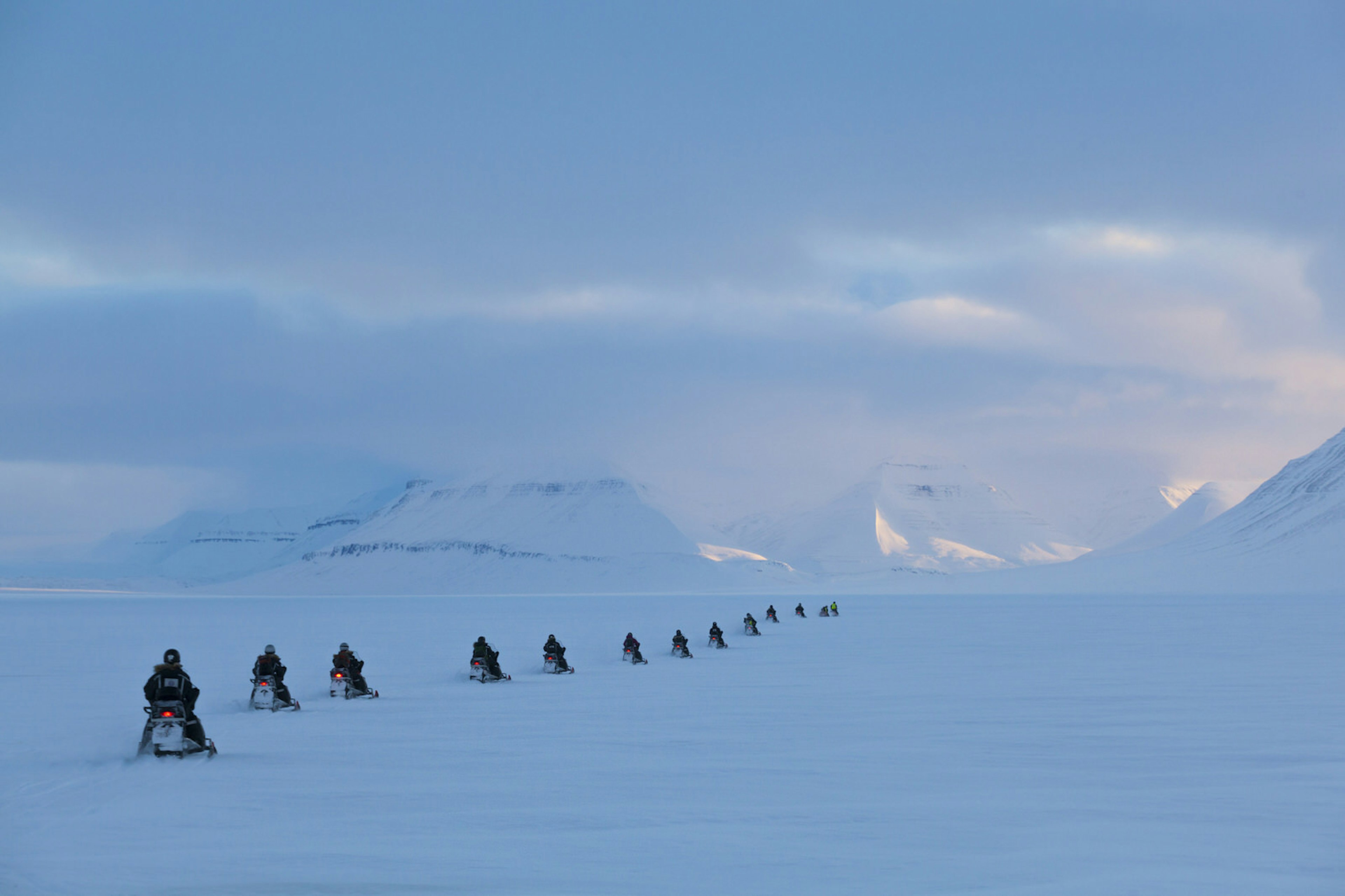 A group of people on snowmobiles exploring Svalbard © Ethan Welty / Getty Images