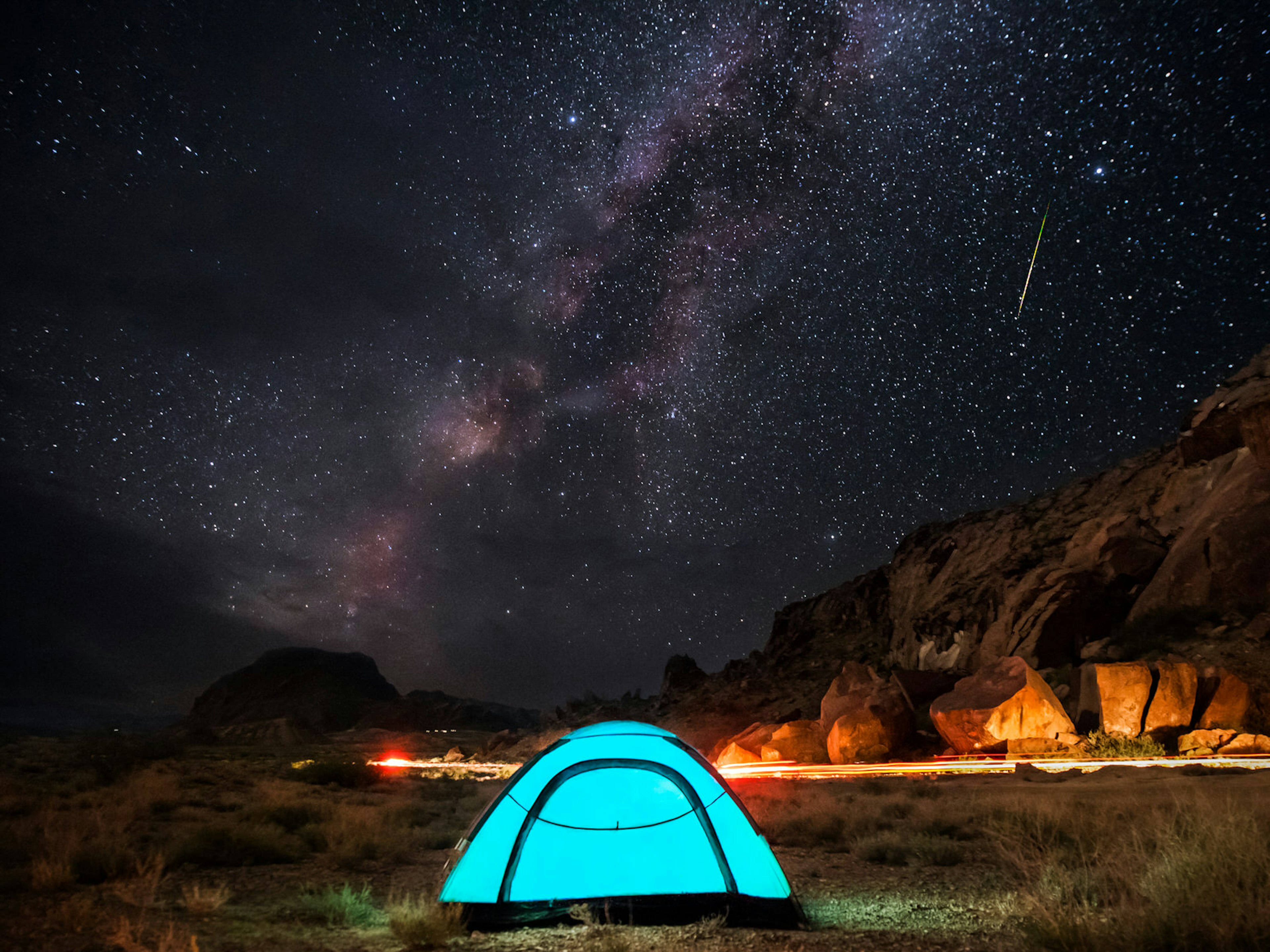 Milky Way, stars and a falling star over a blue tent; Stargazing Southwest USA