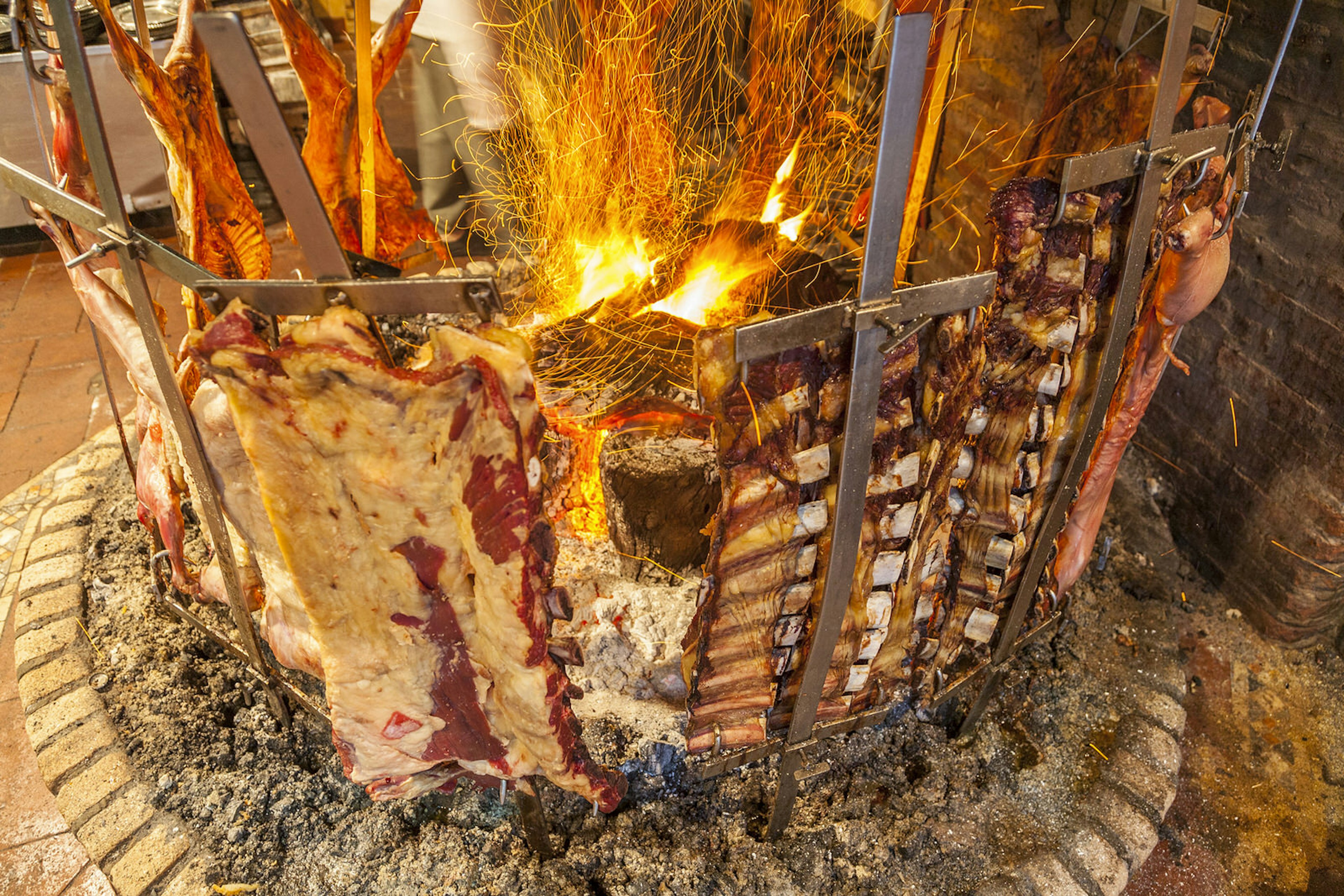 A meat feast cooking over an open flame on a parrilla in Buenos Aires © Stuart Dee / Getty Images