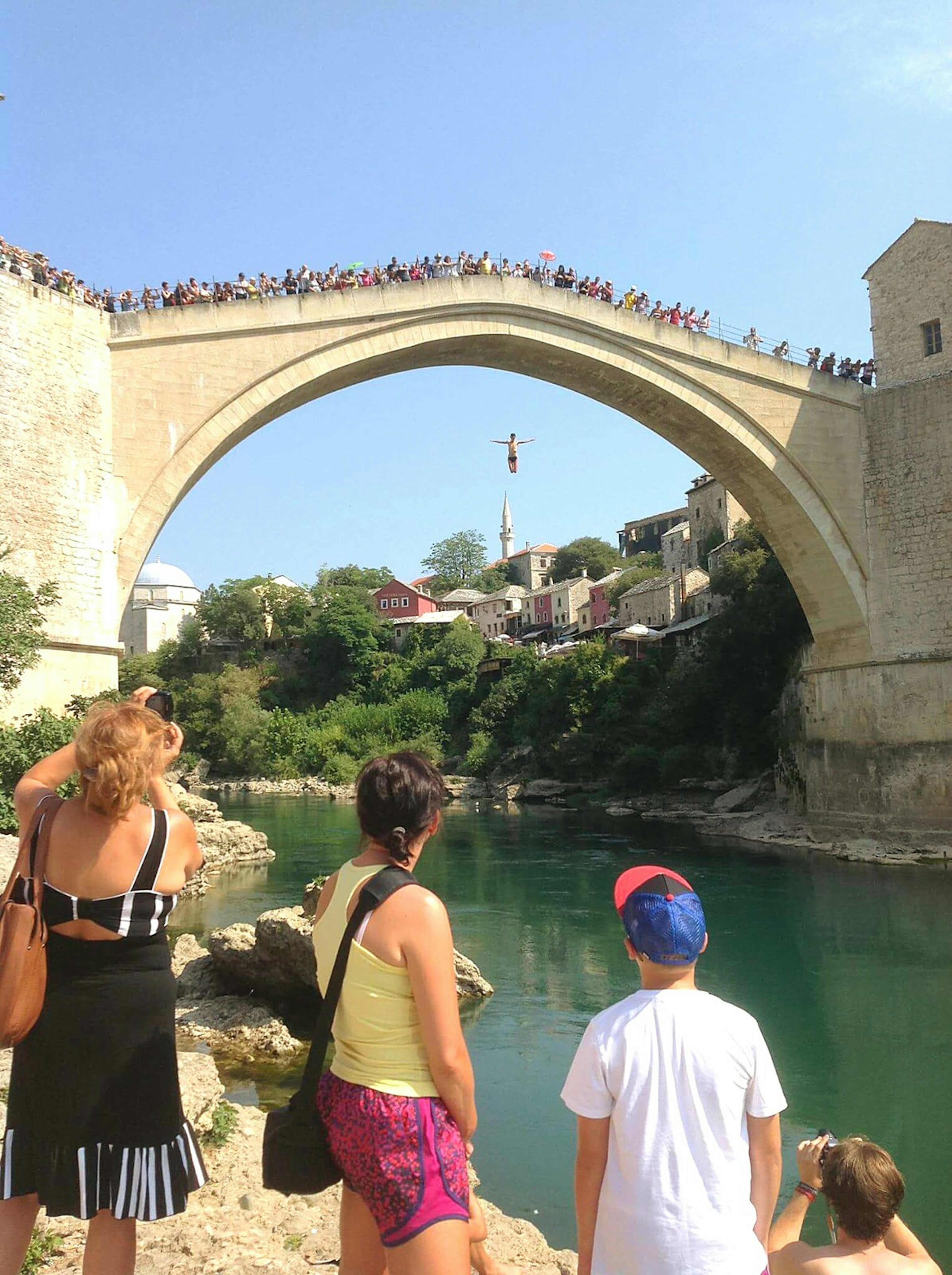 Bystanders look on in awe as a man jumps from Stari Most bridge