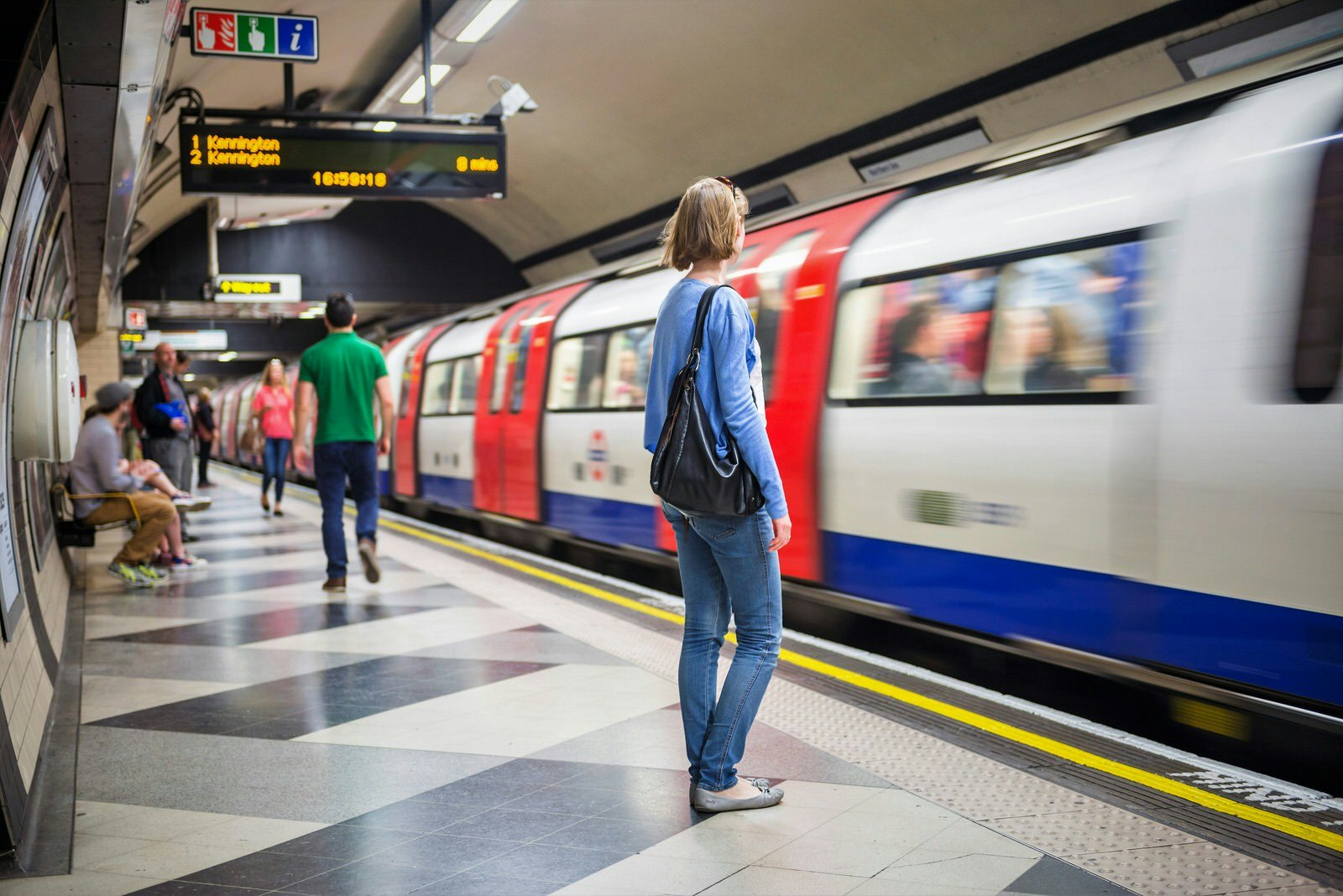 Passengers wait for a Northern Line train at Waterloo Tube station in London