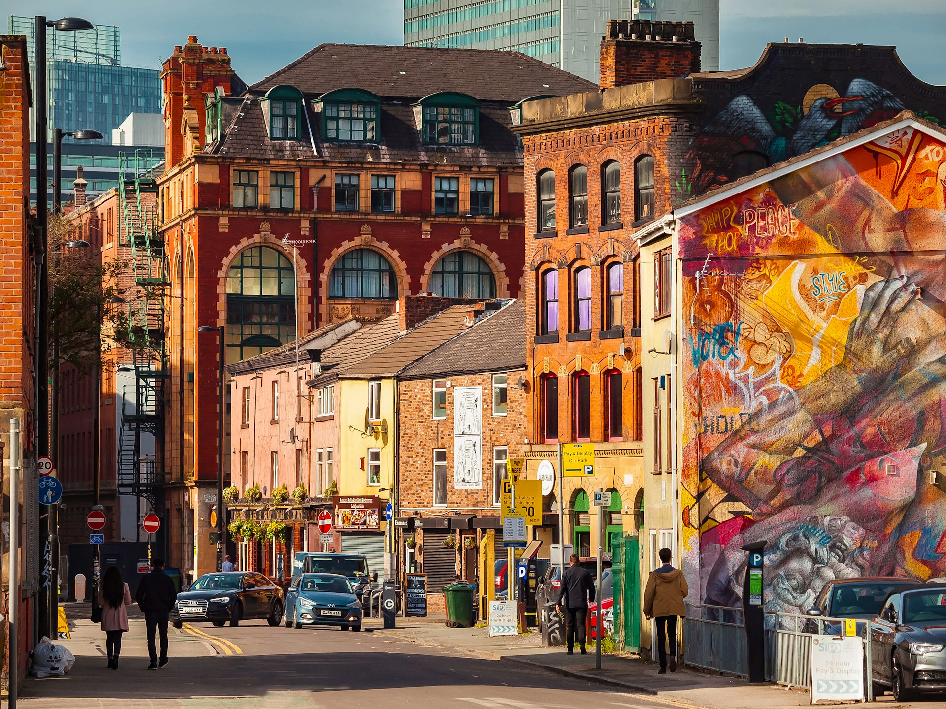 Colorful murals enliven historic buildings on a street in the Northern Quarter, one of Manchester’s most creative neighborhoods