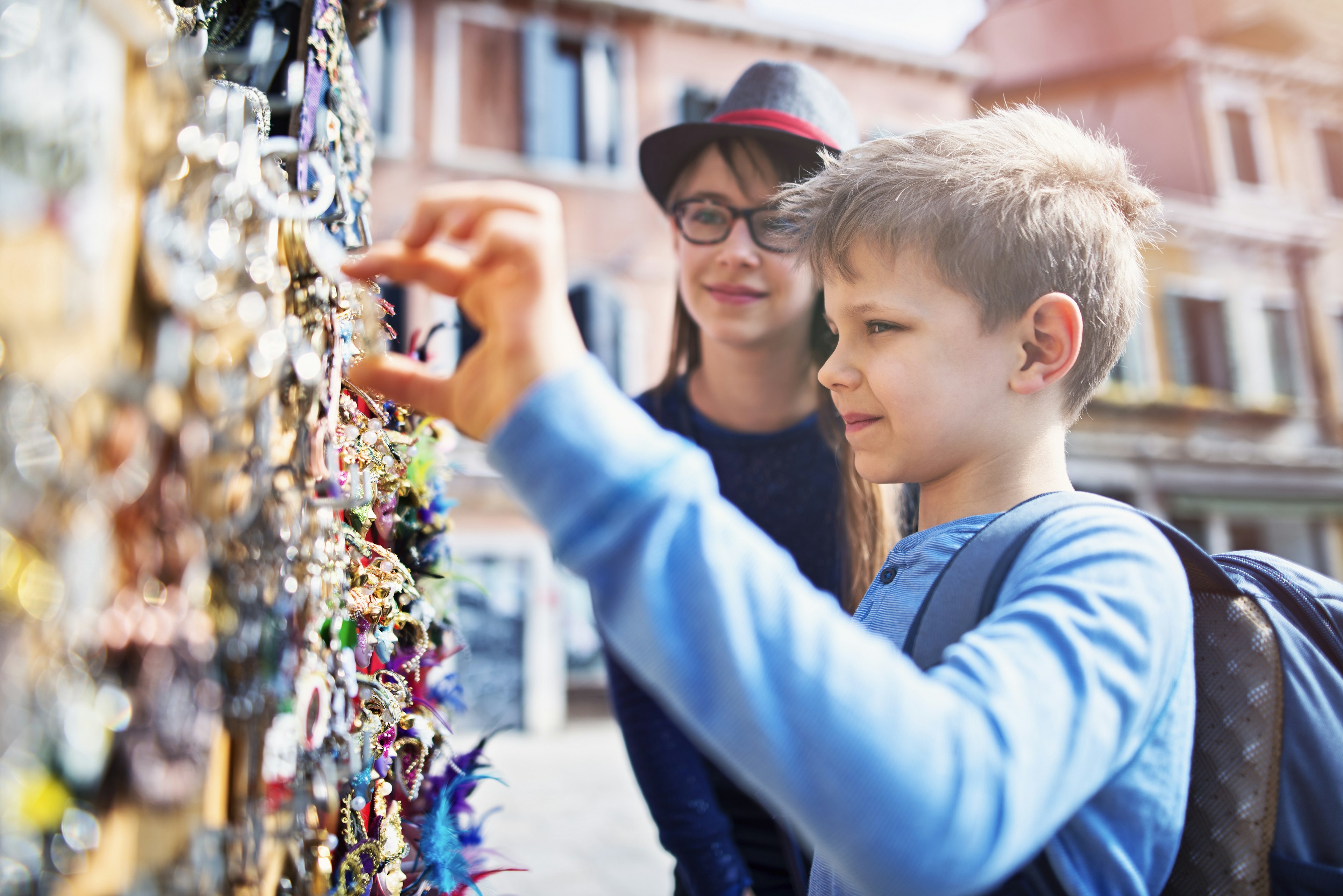 A young boy selects a souvenir magnet from a street stall