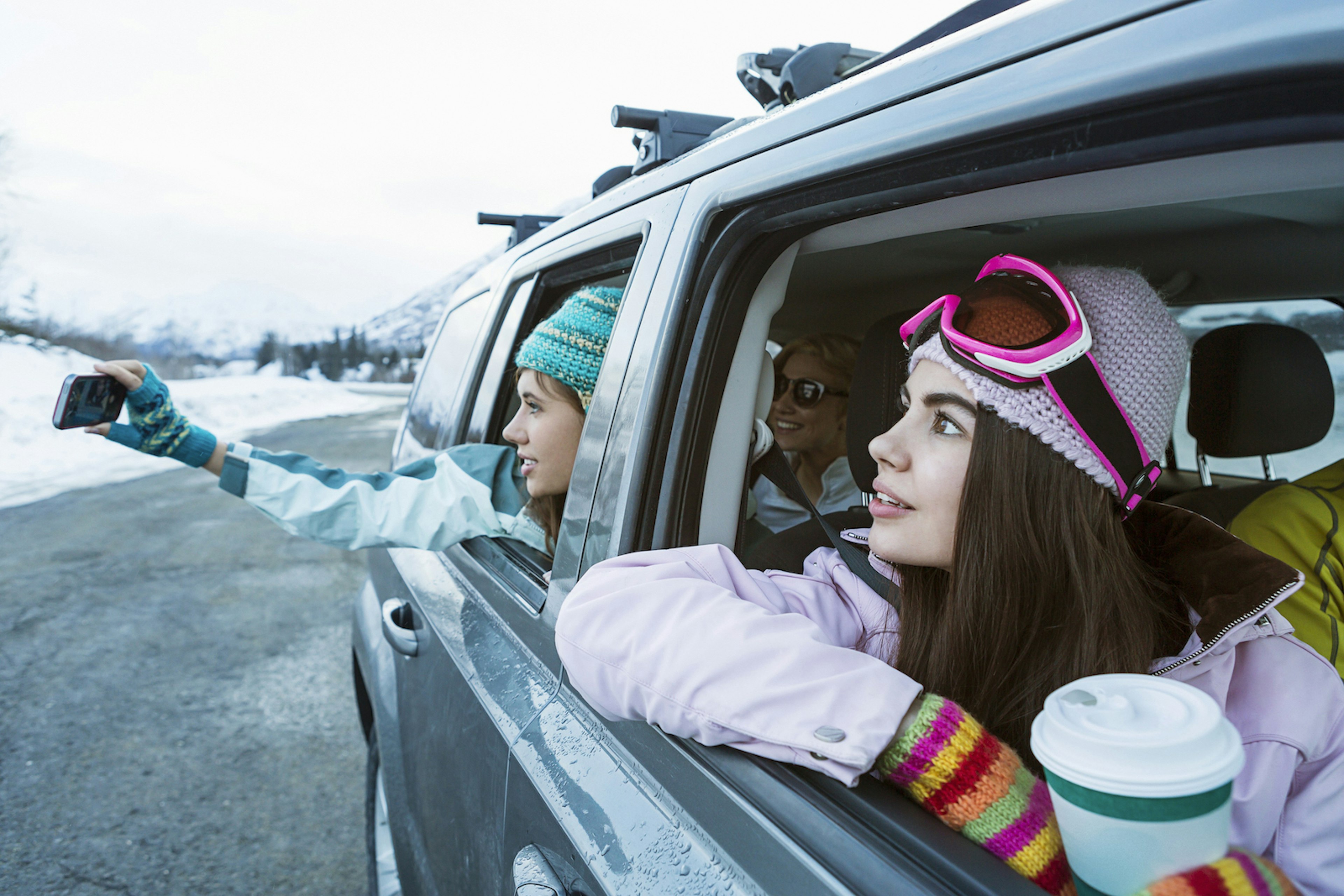 Tourists in a car stopping to take pictures on their phones