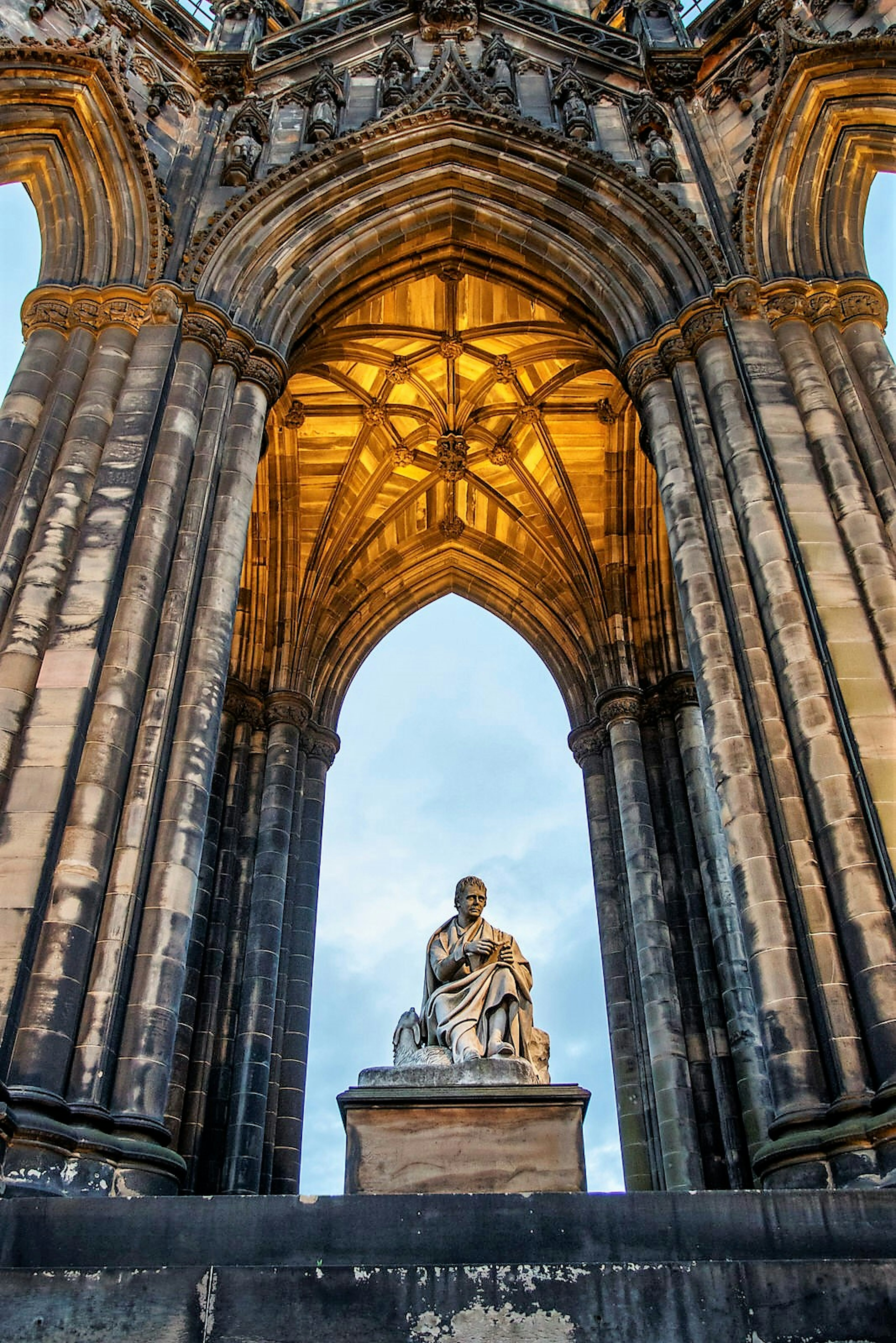 Statue of writer Walter Scott sitting in the middle of the monument dedicated to him