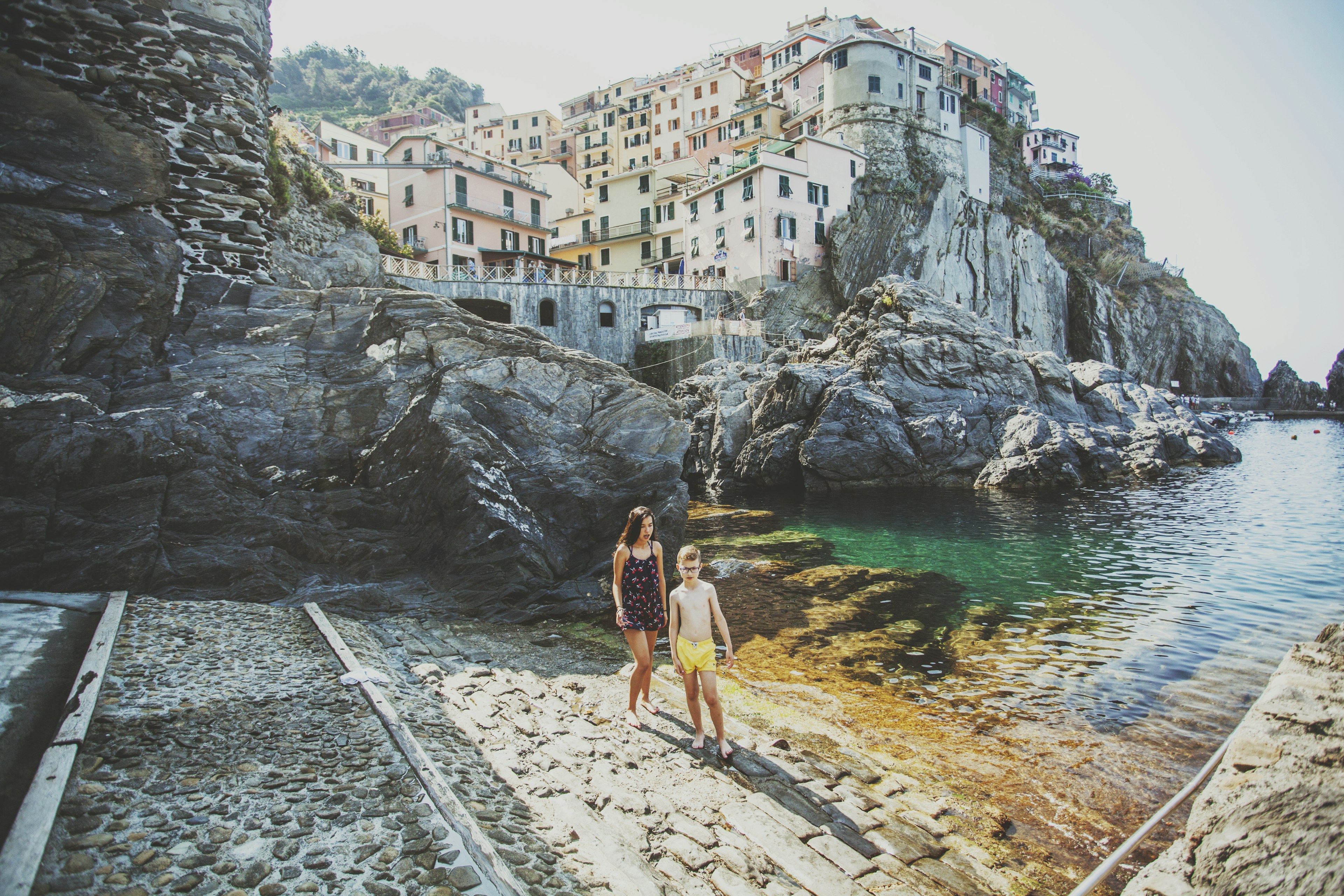 Two kids exploring the shore in Cinque Terre Italy