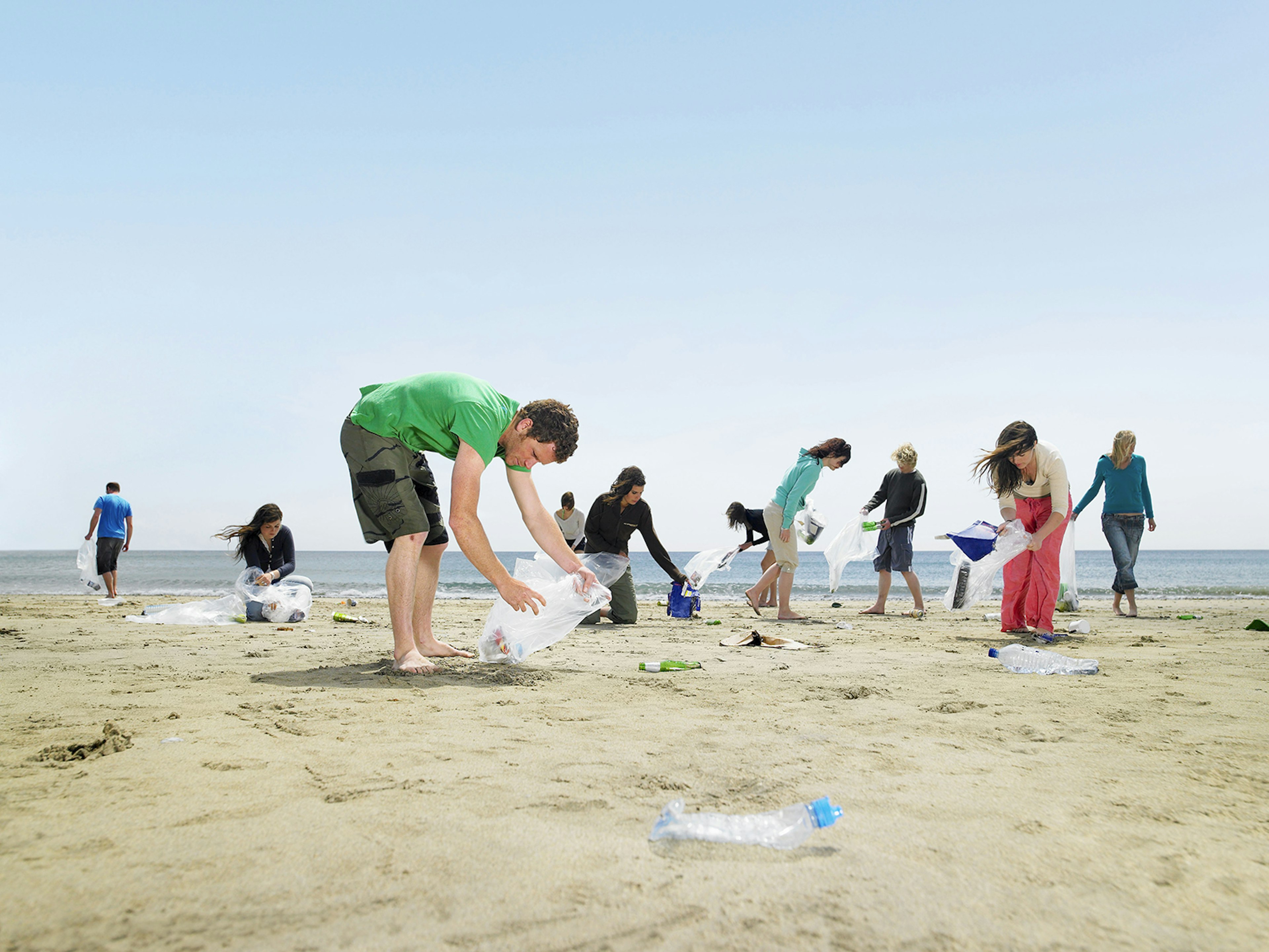 A group of young people clearing plastic from a beach in Cornwall, England © Frank and Helena / Getty Images