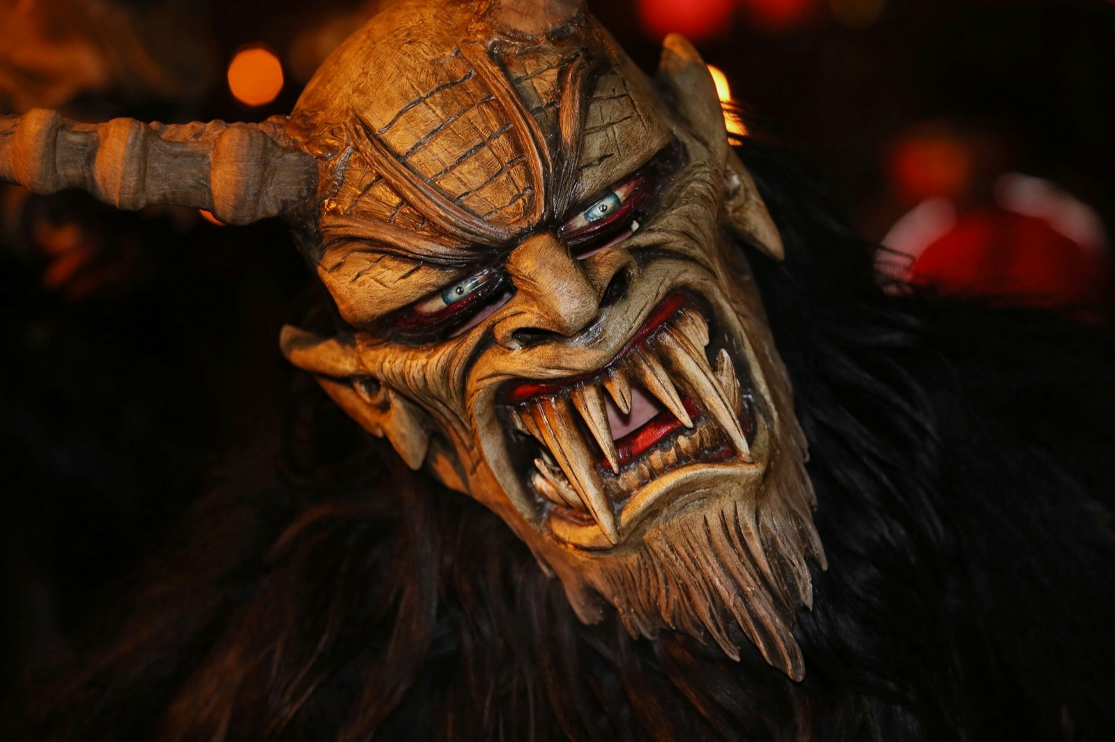 A man in a scary mask stares at the camera