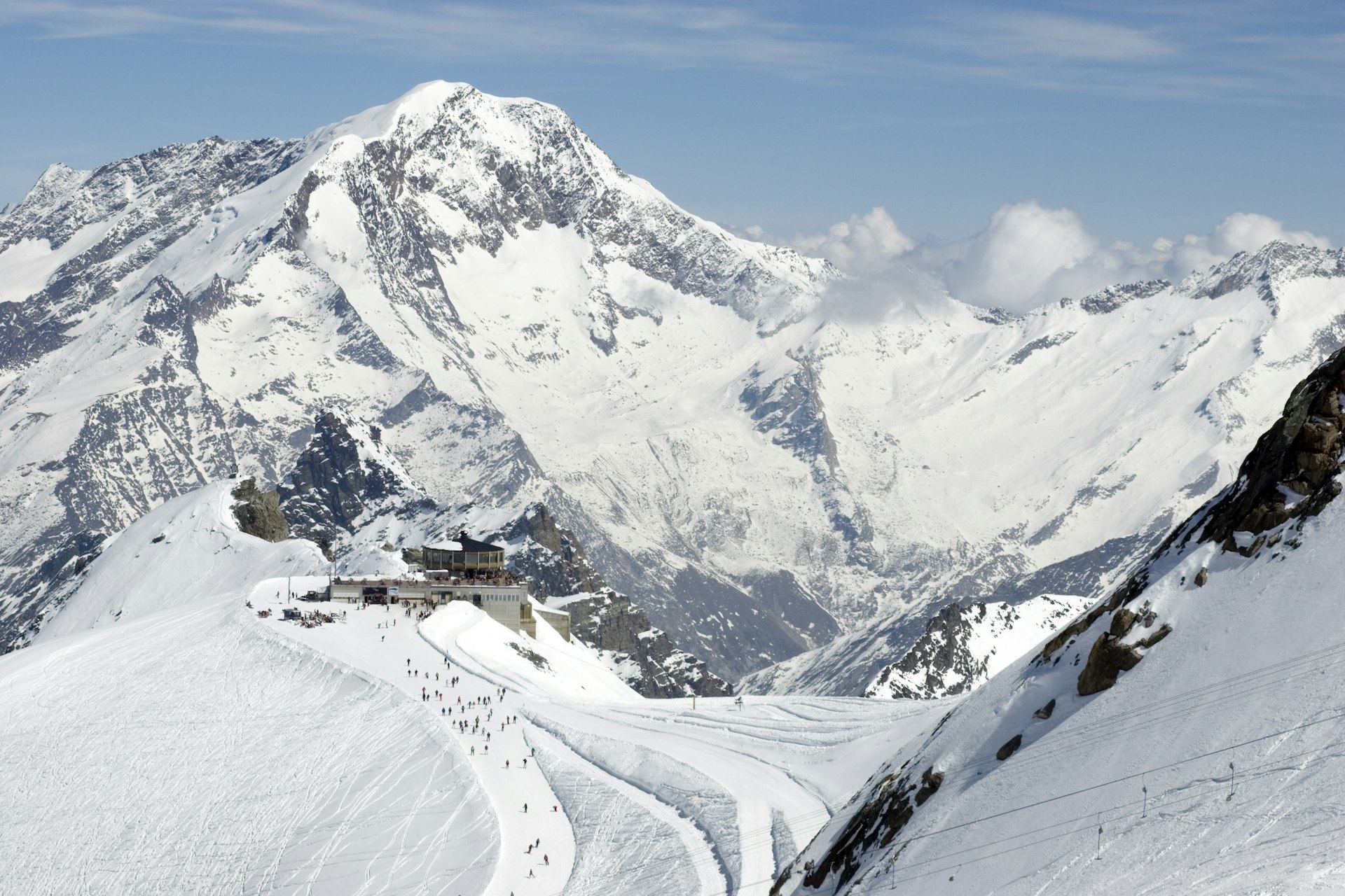 Allalin lift station and revolving restaurant in Saas Fee. The a circular building stands on top of a mountain with views across the Swiss Alps