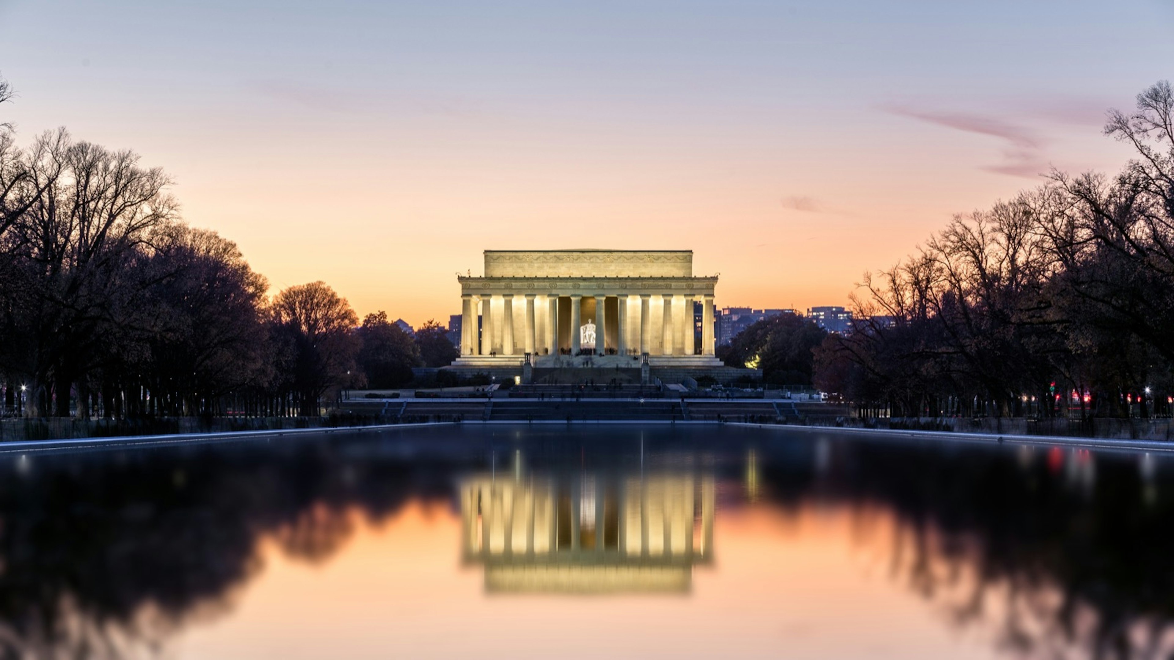 The Lincoln Memorial lit up at night reflected in the pond below. A trip to Washington isn't complete without a selection from the audiobooks for US road trips.