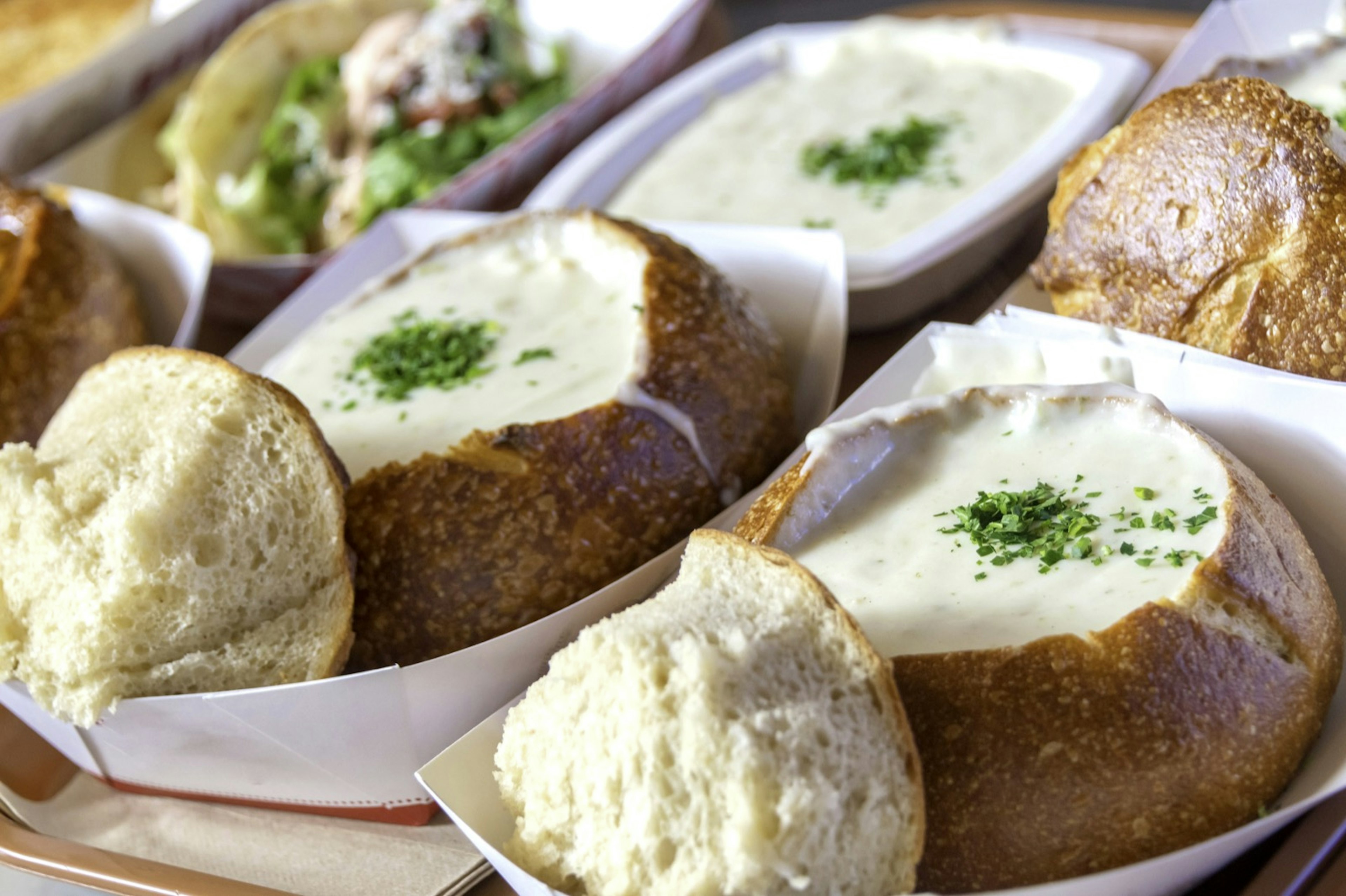 Clam chowder in bread bowls served over the counter in a cardboard plate. Weekend in San Francisco