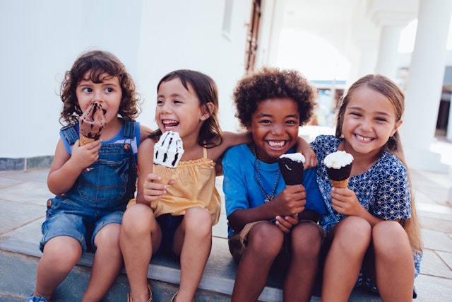 Four kids enjoy ice cream together smiling © Wundervisuals / Getty Images