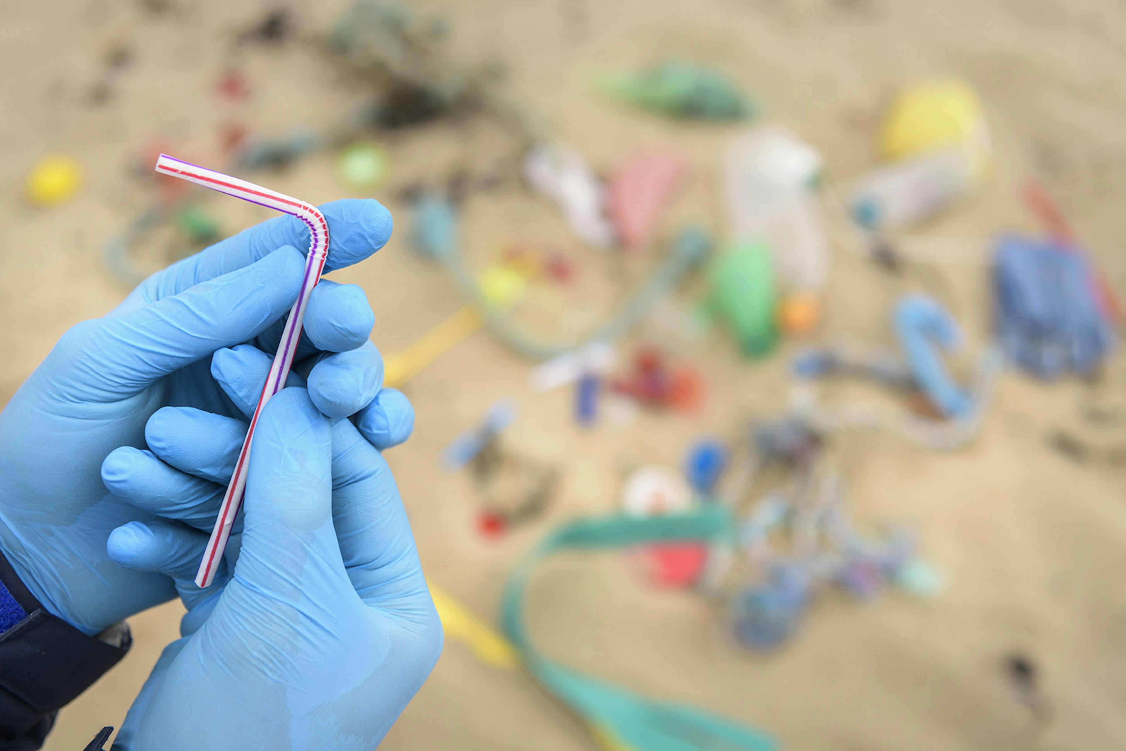 Close-up of a plastic straw found on a beach amid other rubbish © Monty Rakusen / Getty Images