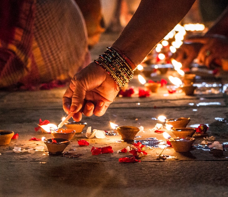 Close-up of a hand lighting incense on the ground at night in Varanasi.
758617141
Human Hand, Varanasi, Color Image, Focus, Celebration, India, Real People, Adults Only, Illumination, Photography, Image Focus Technique, People, Part Of, One Woman Only, Horizontal, Holding, Only Women, Hold, Adult, Human Body Part, Glowing, Selective Focus, Oil Lamp, Close-up, Diwali, Street, Women, Bracelet, Spirituality, Diya - Oil Lamp, Religion, Petal, One Person, Flame, Heat - Temperature, Candle, Illuminated, Lifestyles, Outdoors, Burning, Night